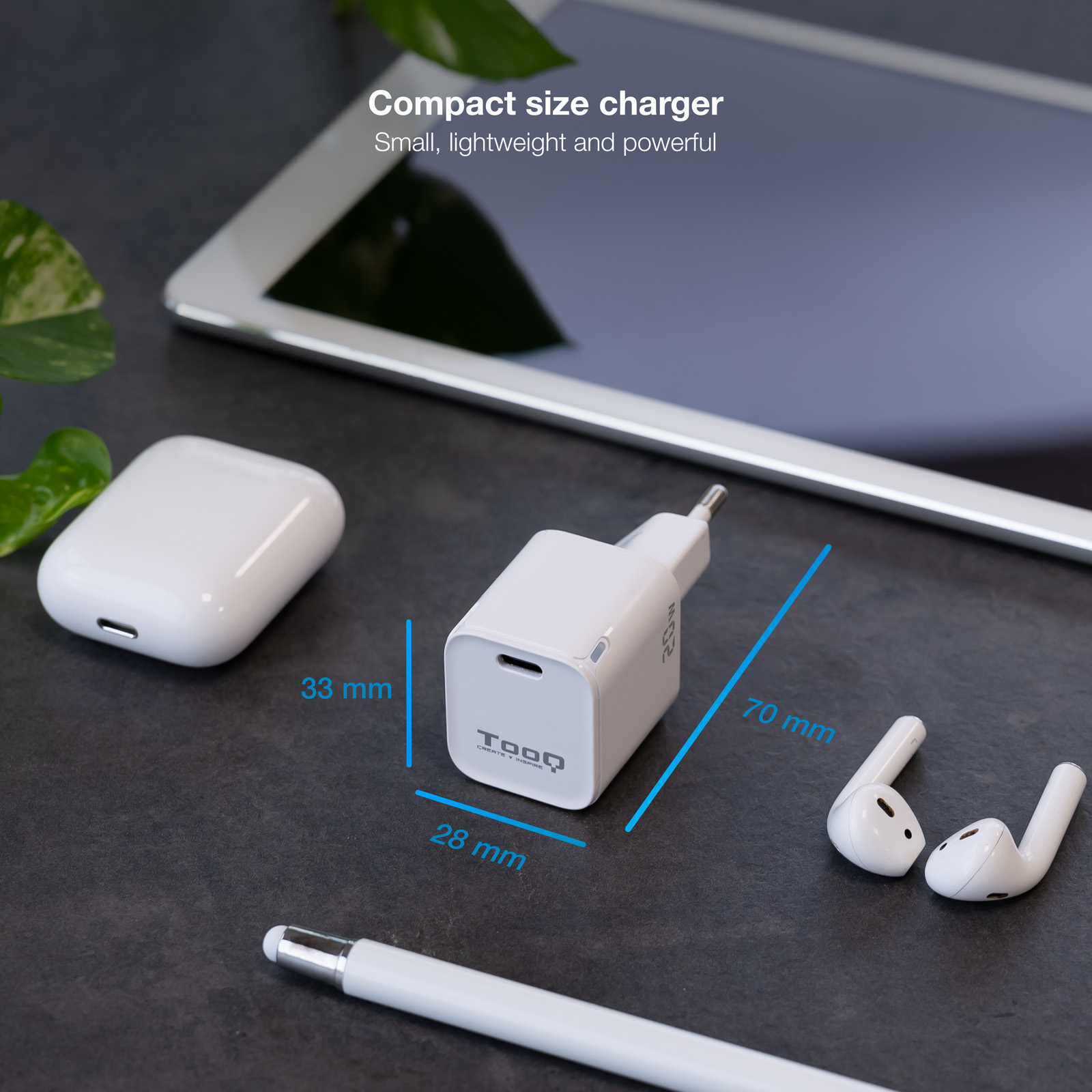 Cargador blanco, auriculares y lápiz óptico sobre una superficie oscura. Se muestran las dimensiones del cargador.