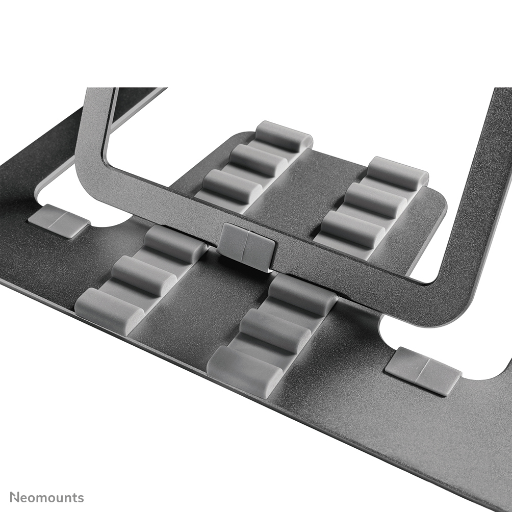 A close-up of a silver laptop stand. It has grey rubber pads to hold the laptop and is made of metal.