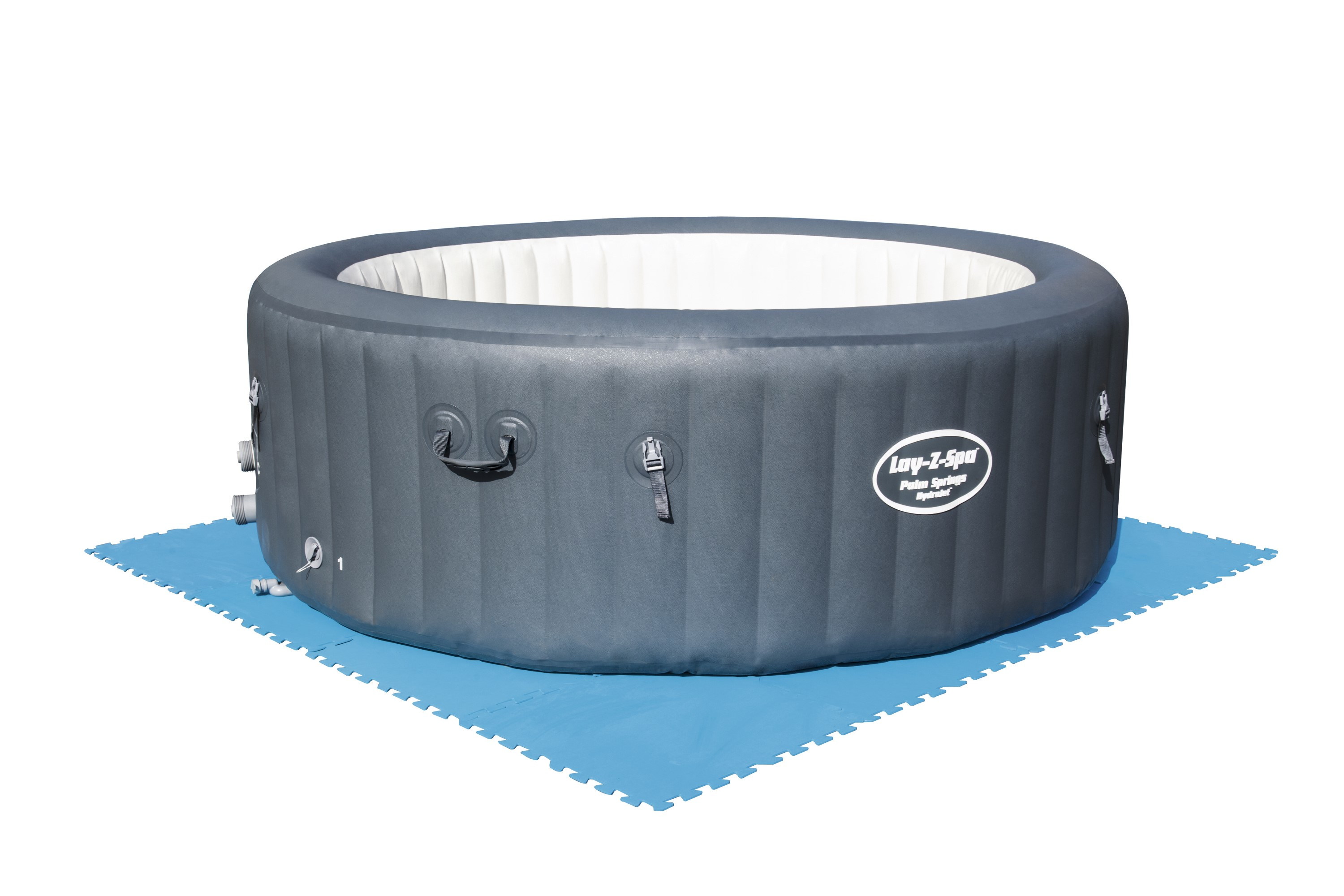 Een grijze opblaasbare hot tub met een wit interieur staat op een blauwe mat. De tub heeft een logo en handvatten.