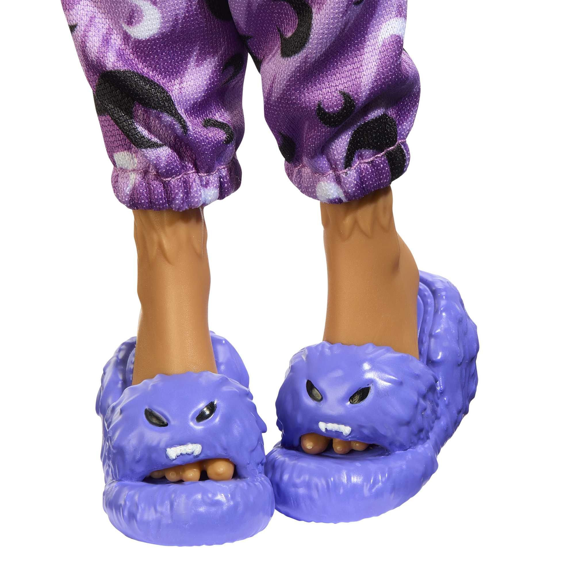 Puppenbeine in lila Camouflage-Hose, mit lila Monster-Hausschuhen mit offenem Mund und Zähnen, auf Weiß.