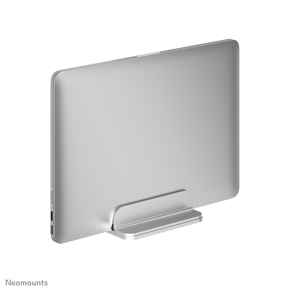 A silver laptop is held vertically in a silver stand. The stand is on a white background. The laptop's ports are visible.