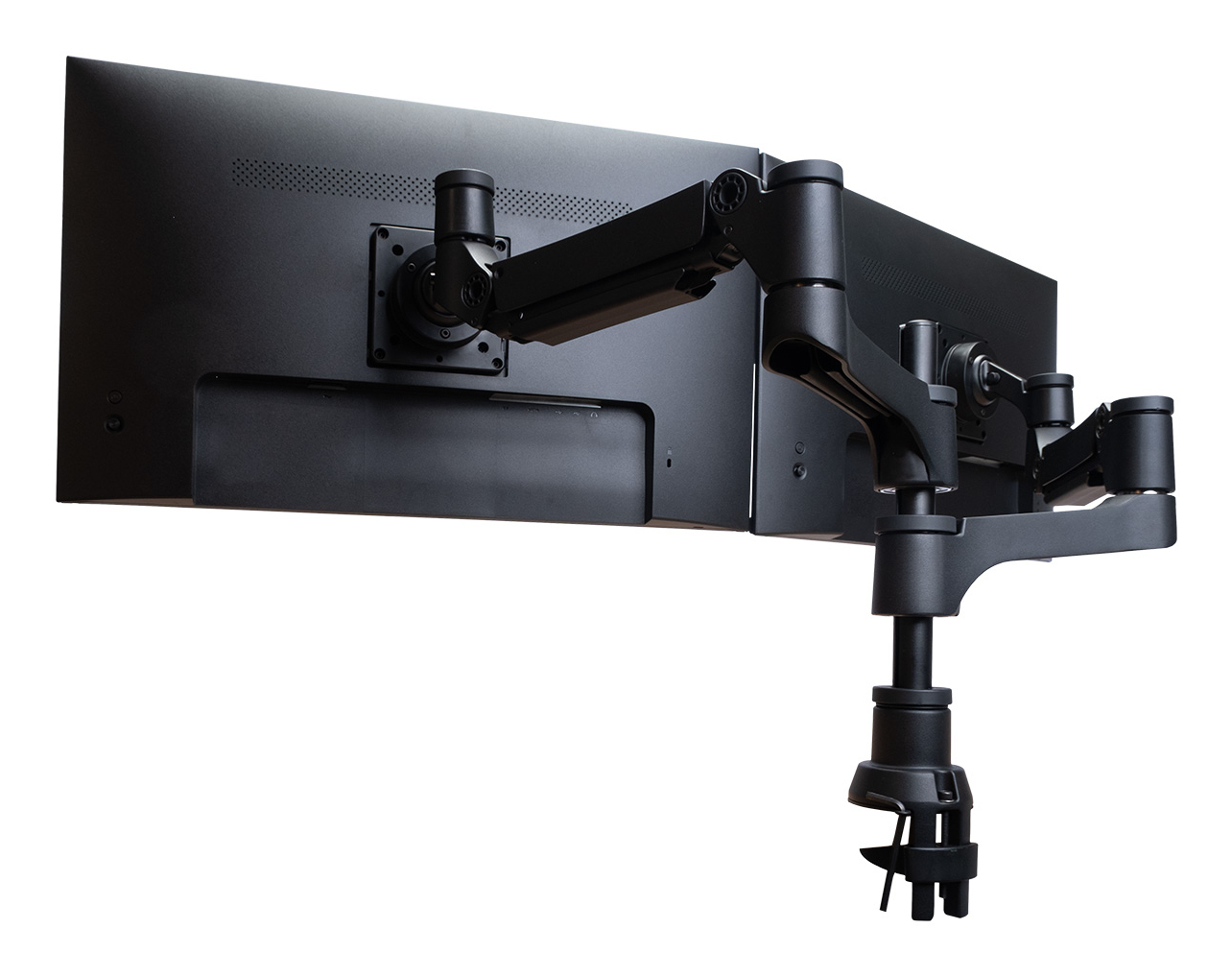 A black dual monitor arm is mounted to two black monitors. The arm has multiple joints and clamps to a desk.