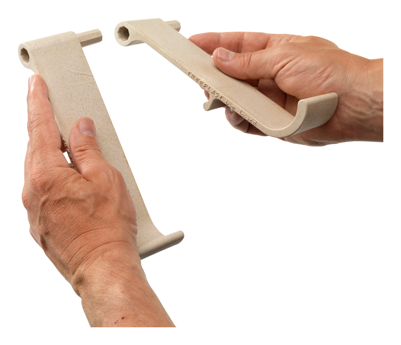 Two beige plastic holders are held by hands against a white background. One is held in the hand and the other is not attached.