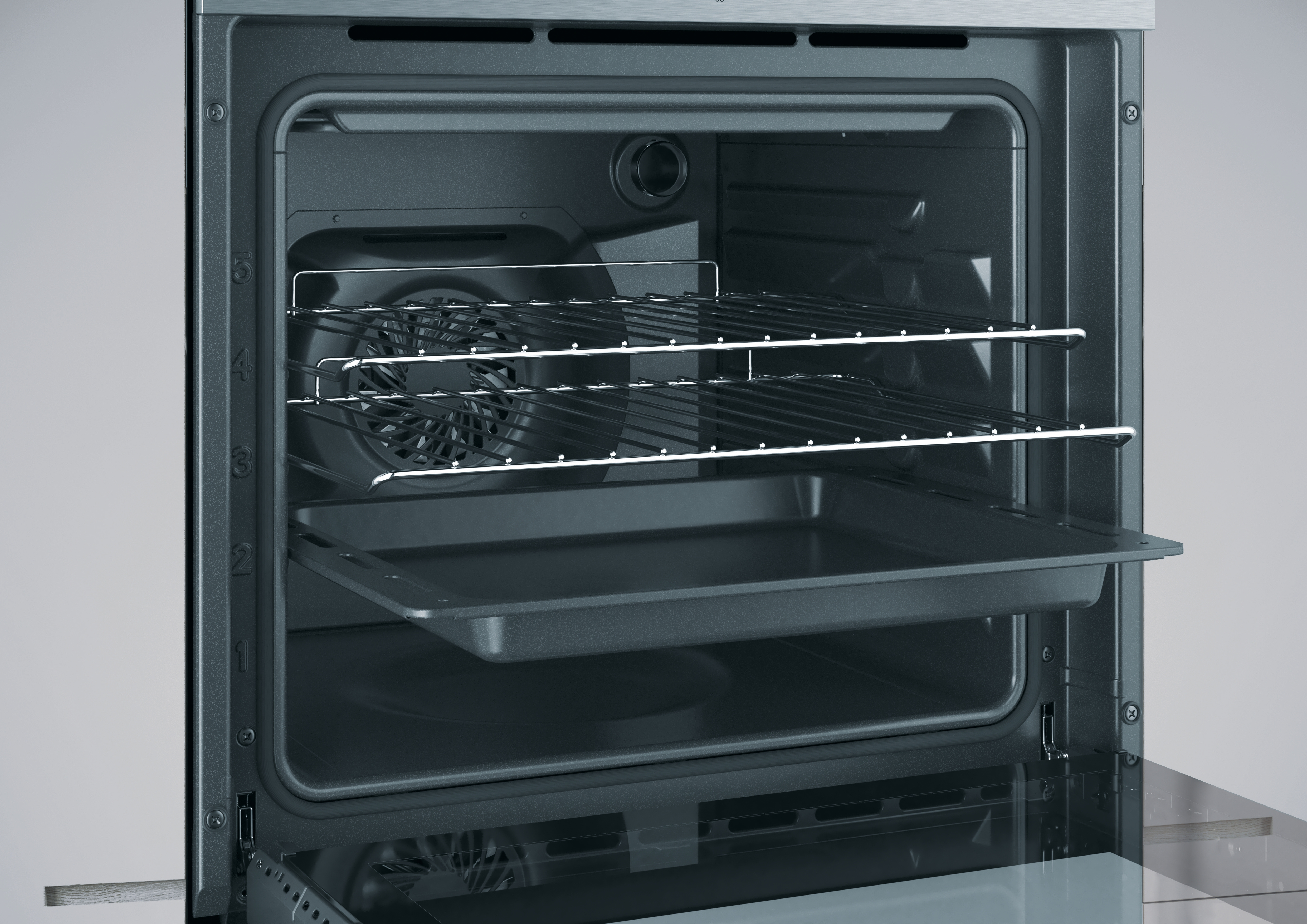 Interno di un forno con griglie e vassoio. Una ventola è visibile sul retro. La porta del forno è parzialmente aperta.