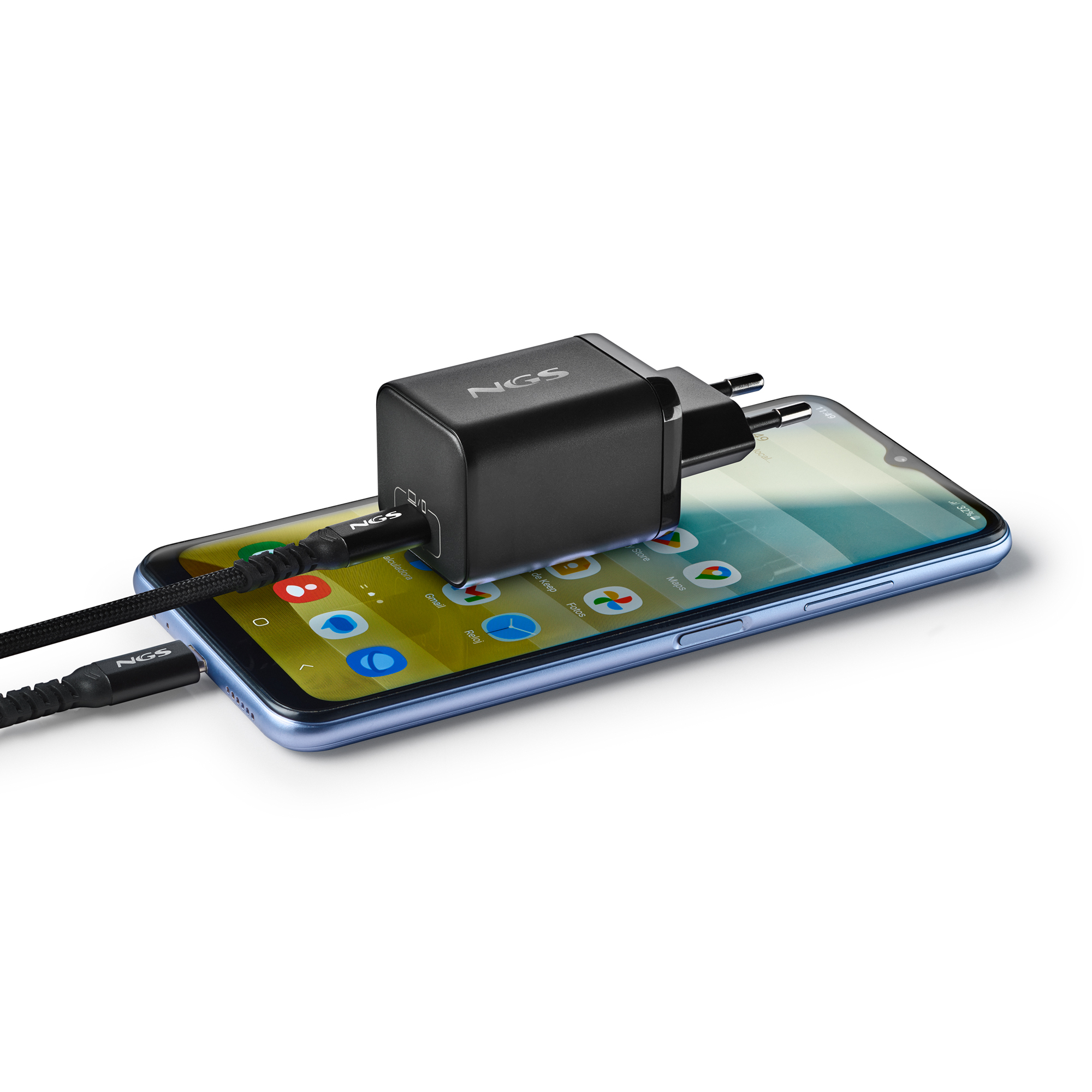 Un cargador negro con cable enchufado a un smartphone. El teléfono muestra iconos de aplicaciones.