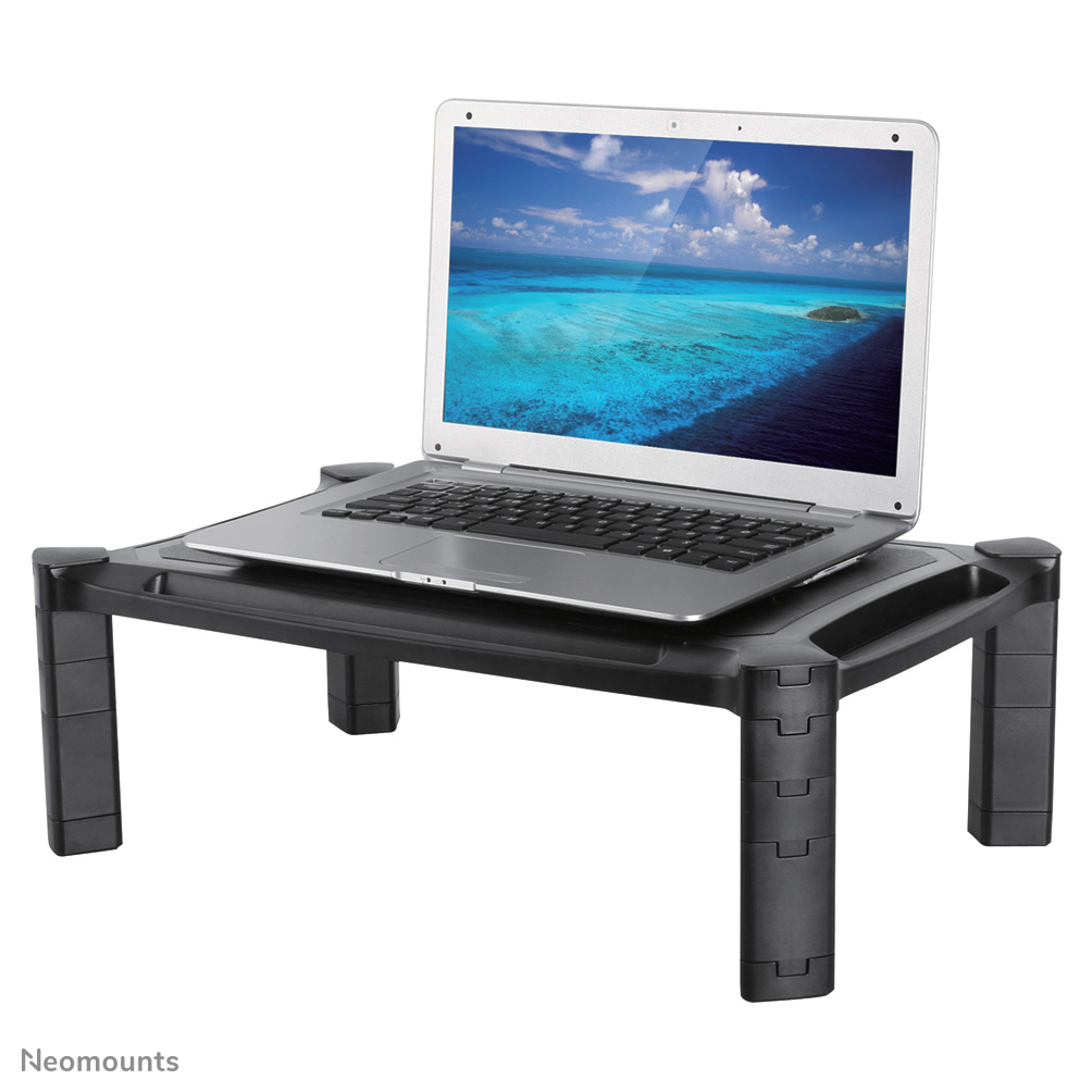 Een laptop staat op een zwarte laptopstandaard. Het scherm toont een tropisch eiland met blauw water en lucht.