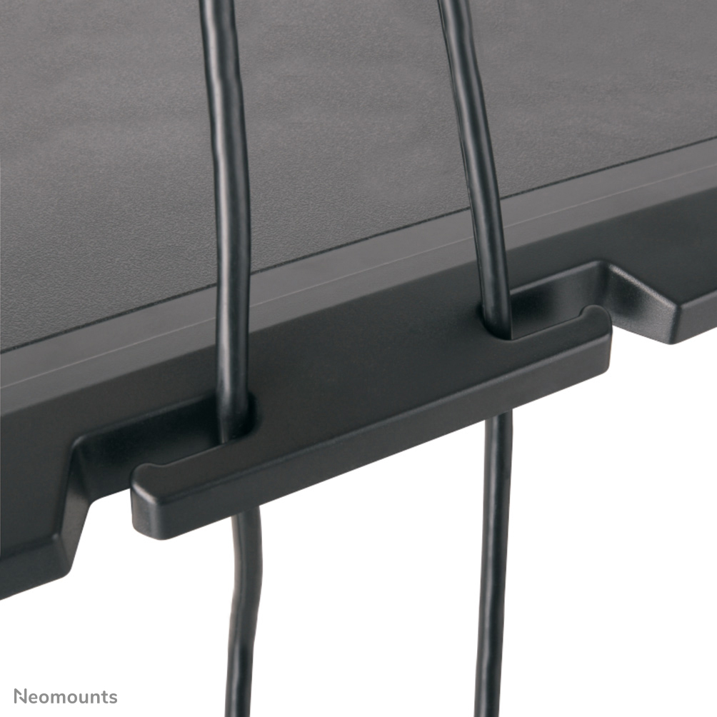 Close-up van een zwarte kabelorganizer. Twee zwarte kabels hangen naar beneden. De organizer heeft een getextureerd oppervlak.