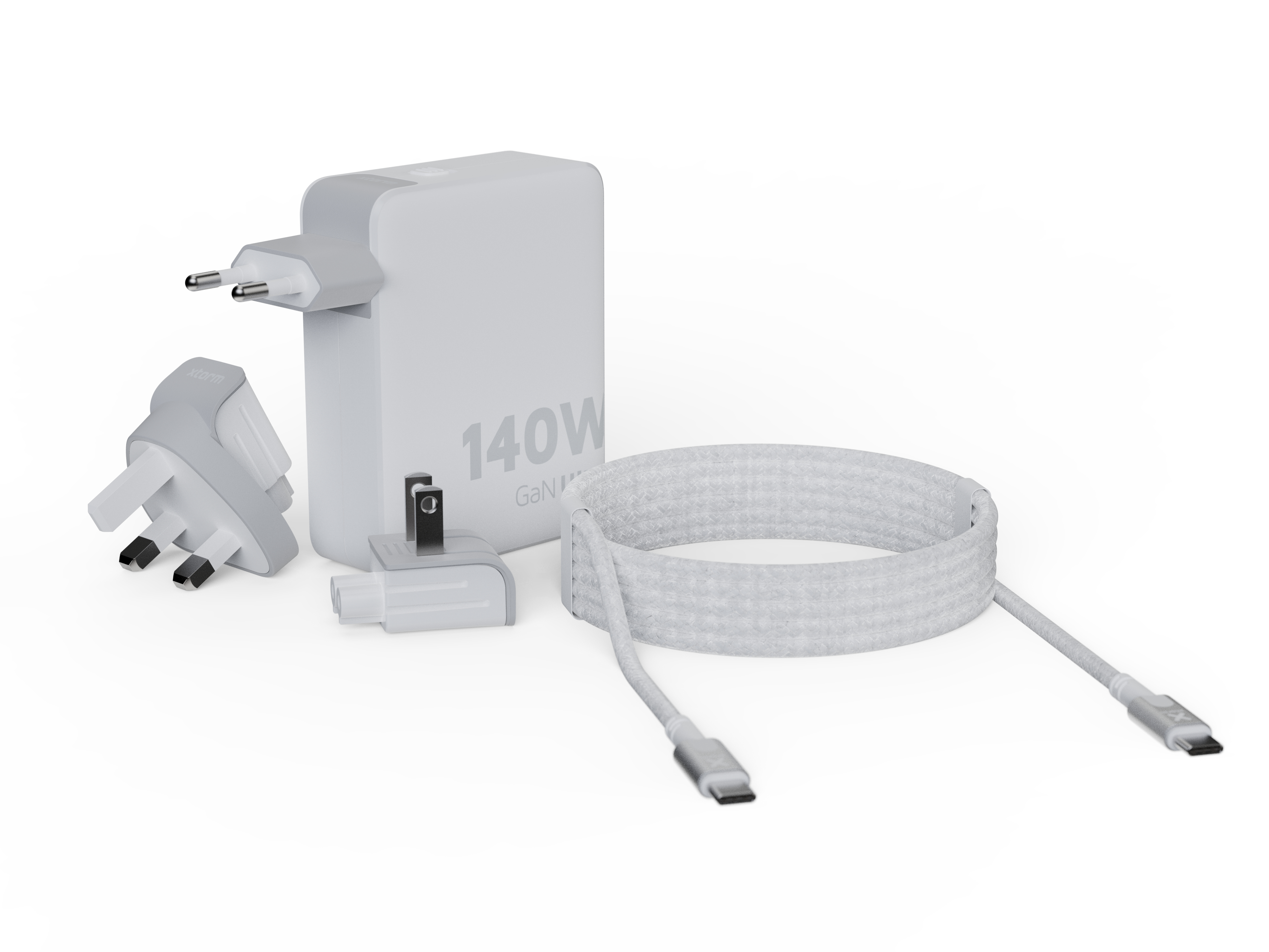 Un chargeur GaN blanc de 140W avec adaptateurs et un câble USB-C blanc sont sur une surface blanche.