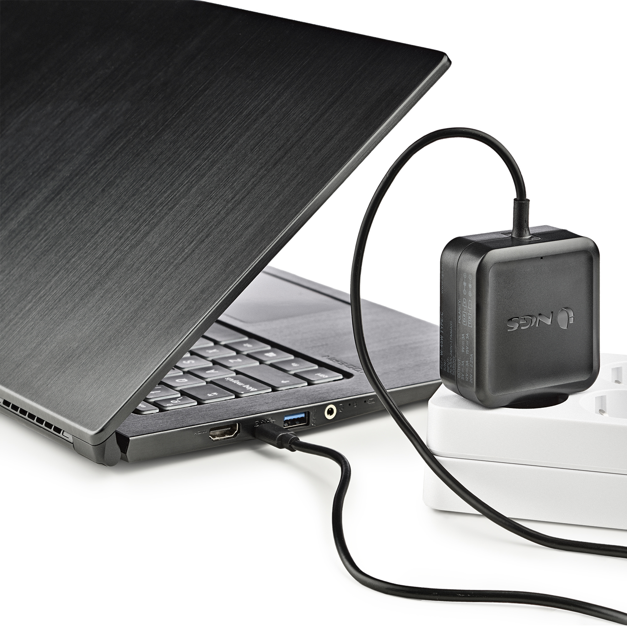 Schwarzer Laptop mit eingestecktem Ladegerät. Ein schwarzes Ladegerät befindet sich in einer Steckdose. Weißer Hintergrund.