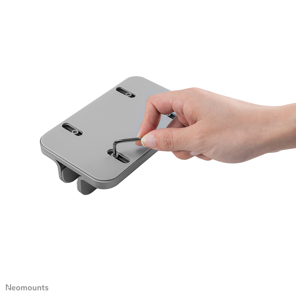 A hand using an Allen wrench to tighten a screw on a gray, rectangular bracket. White background.