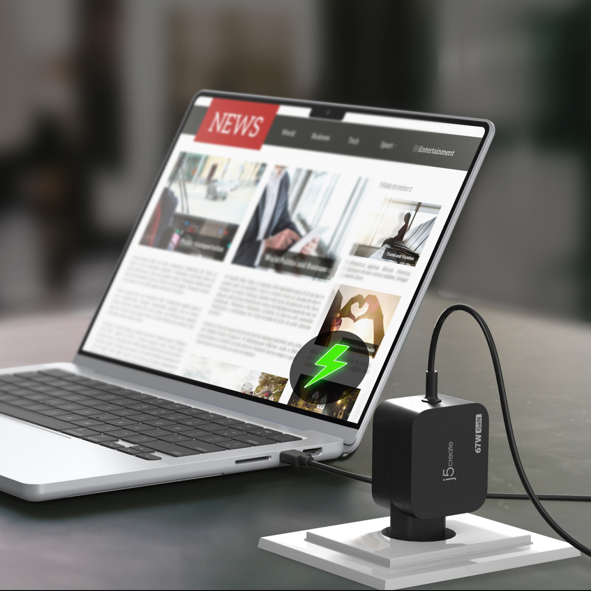 Ordenador portátil que muestra un sitio de noticias, cargándose con un adaptador negro. Un rayo verde en la pantalla.