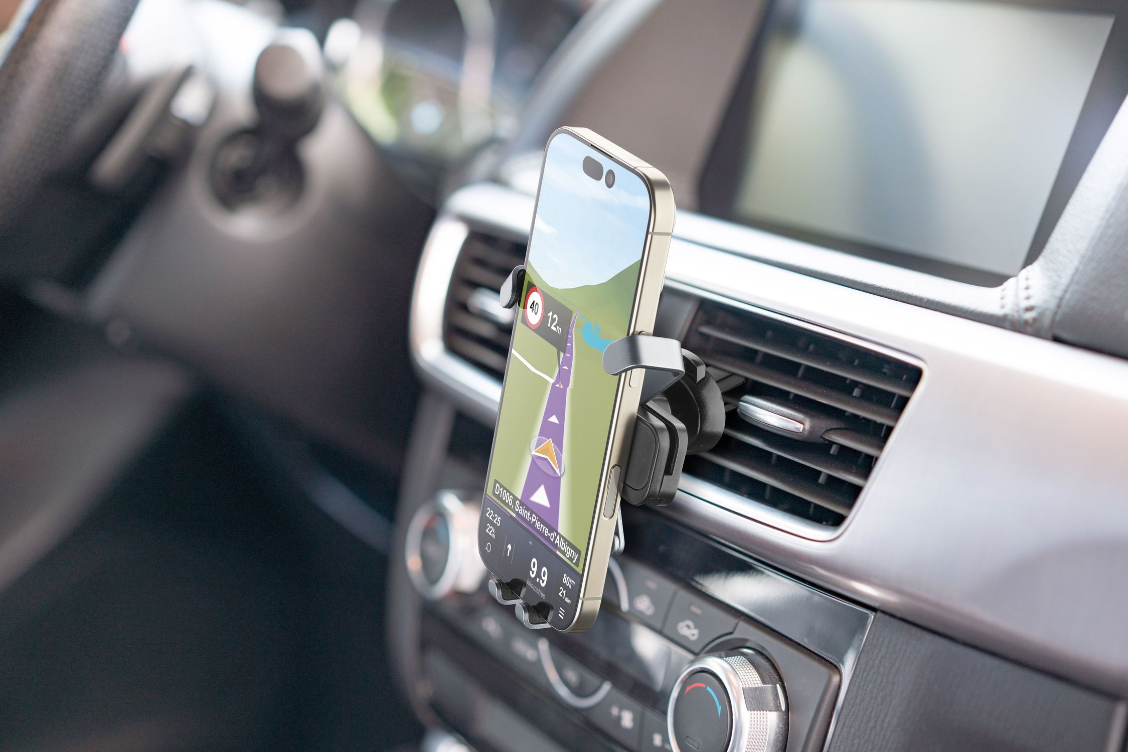 Un teléfono inteligente con GPS está montado en un coche. La pantalla muestra un mapa de navegación. El interior del coche es visible.