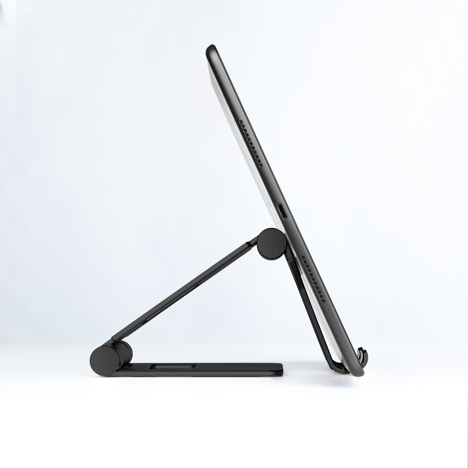 Una tableta negra está apoyada en un soporte negro. El soporte tiene una base y un brazo ajustable.