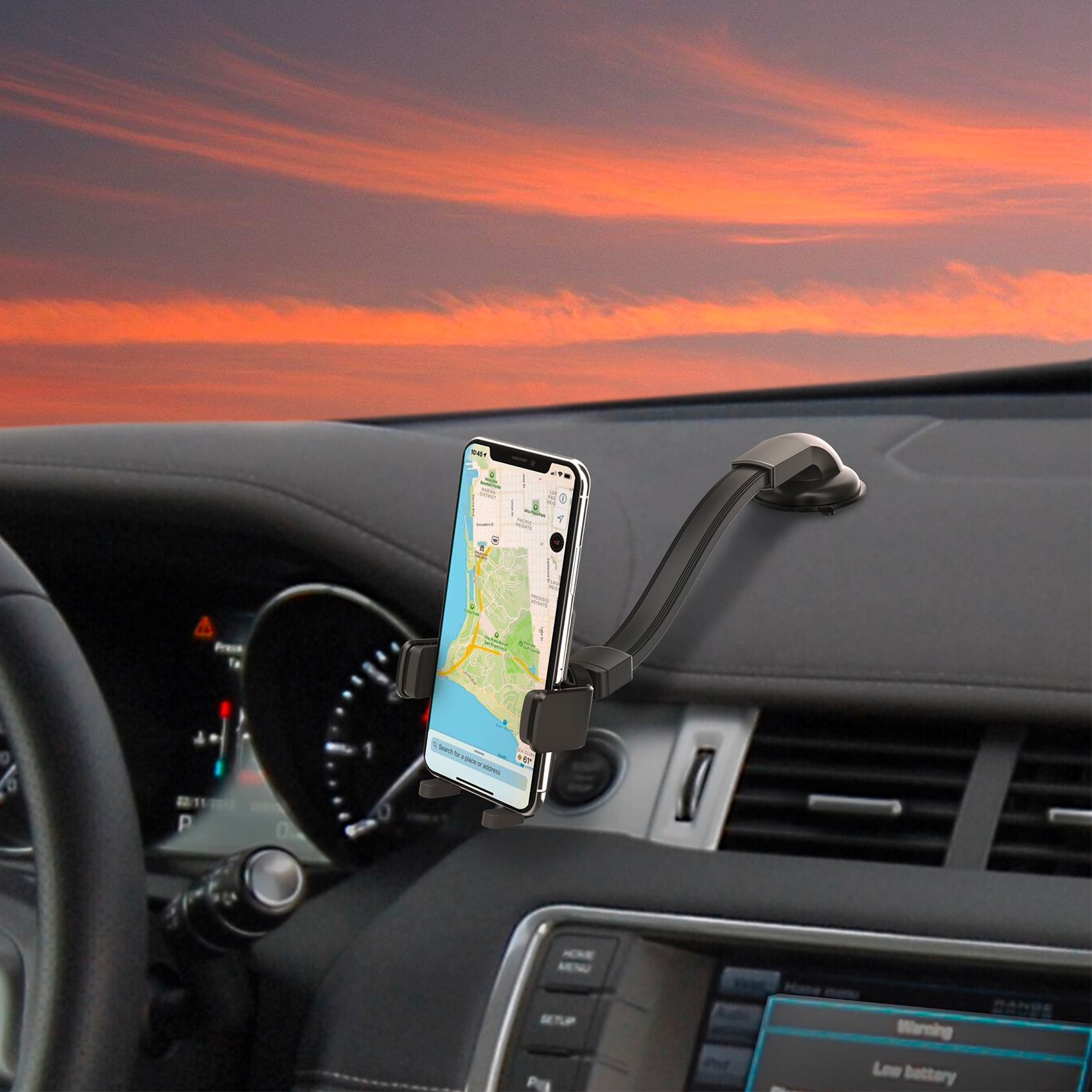 Un teléfono con un mapa está montado en un coche. Cielo al atardecer en el fondo. Se ven el salpicadero y el volante.