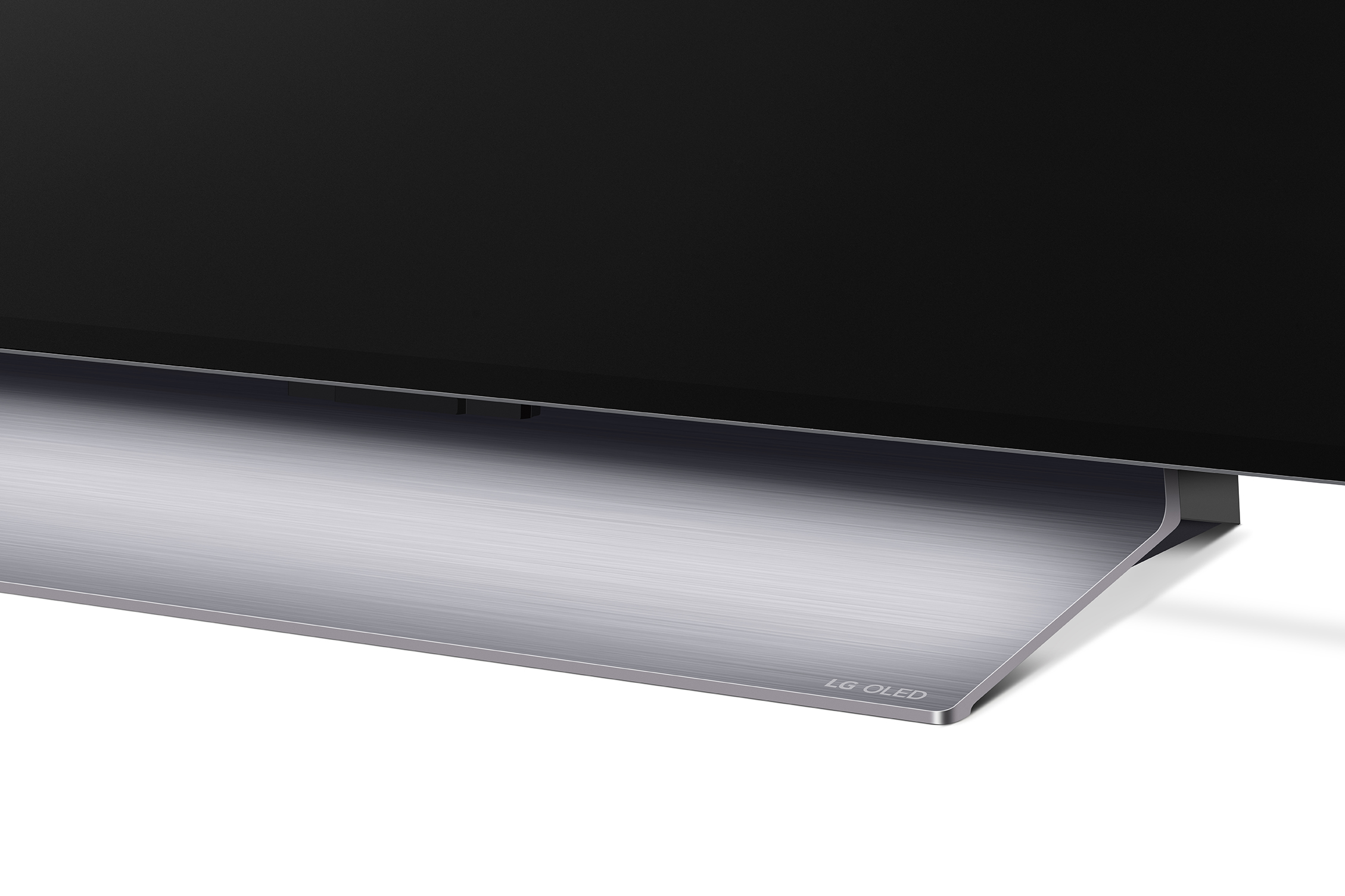 Nahaufnahme eines LG OLED TV-Sockels. Der Sockel ist silberfarben mit dem LG OLED-Logo. Schwarzer TV-Bildschirm darüber.