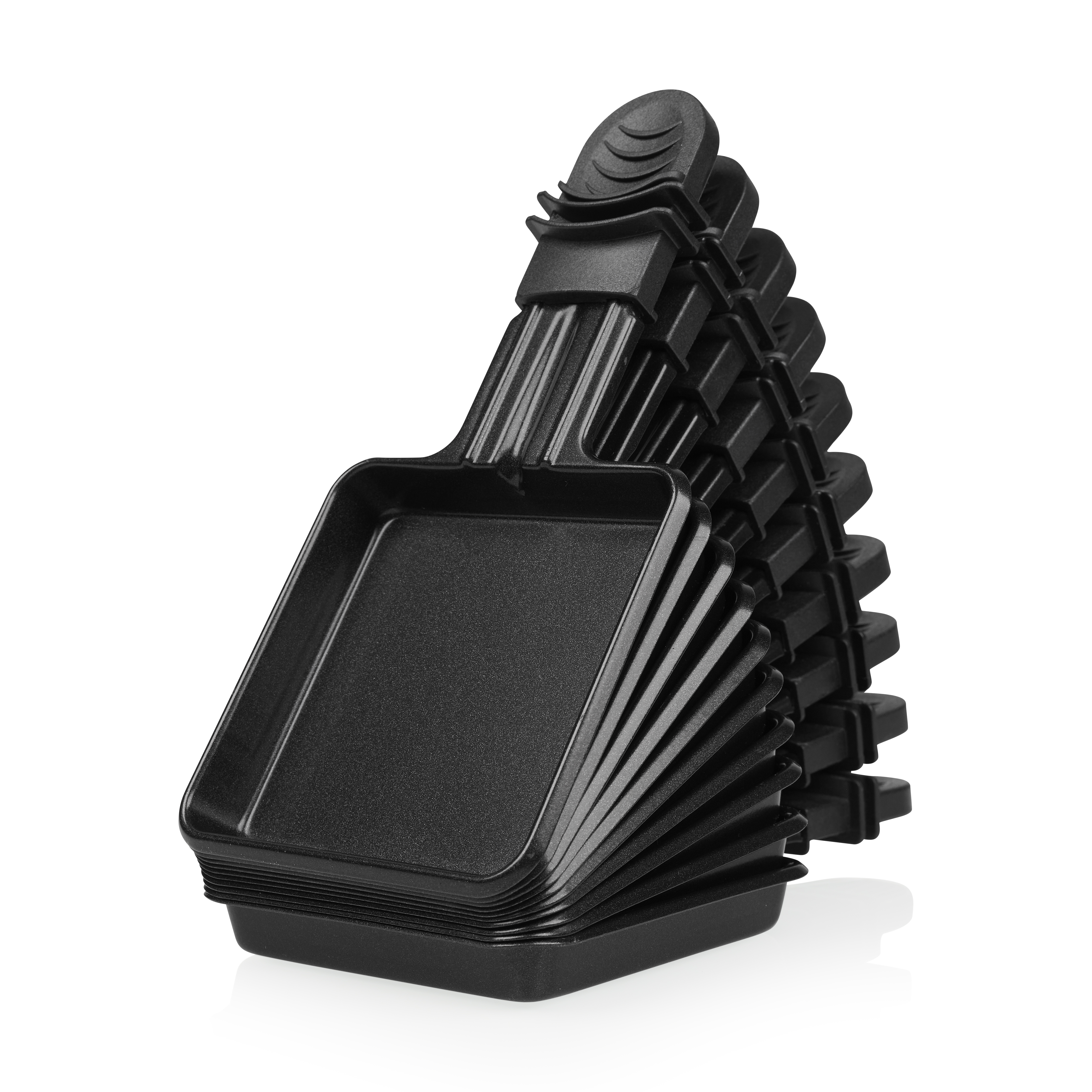 Ein Stapel schwarzer Raclette-Pfannen. Jede Pfanne hat einen Griff. Die Pfannen stehen auf weißem Hintergrund.