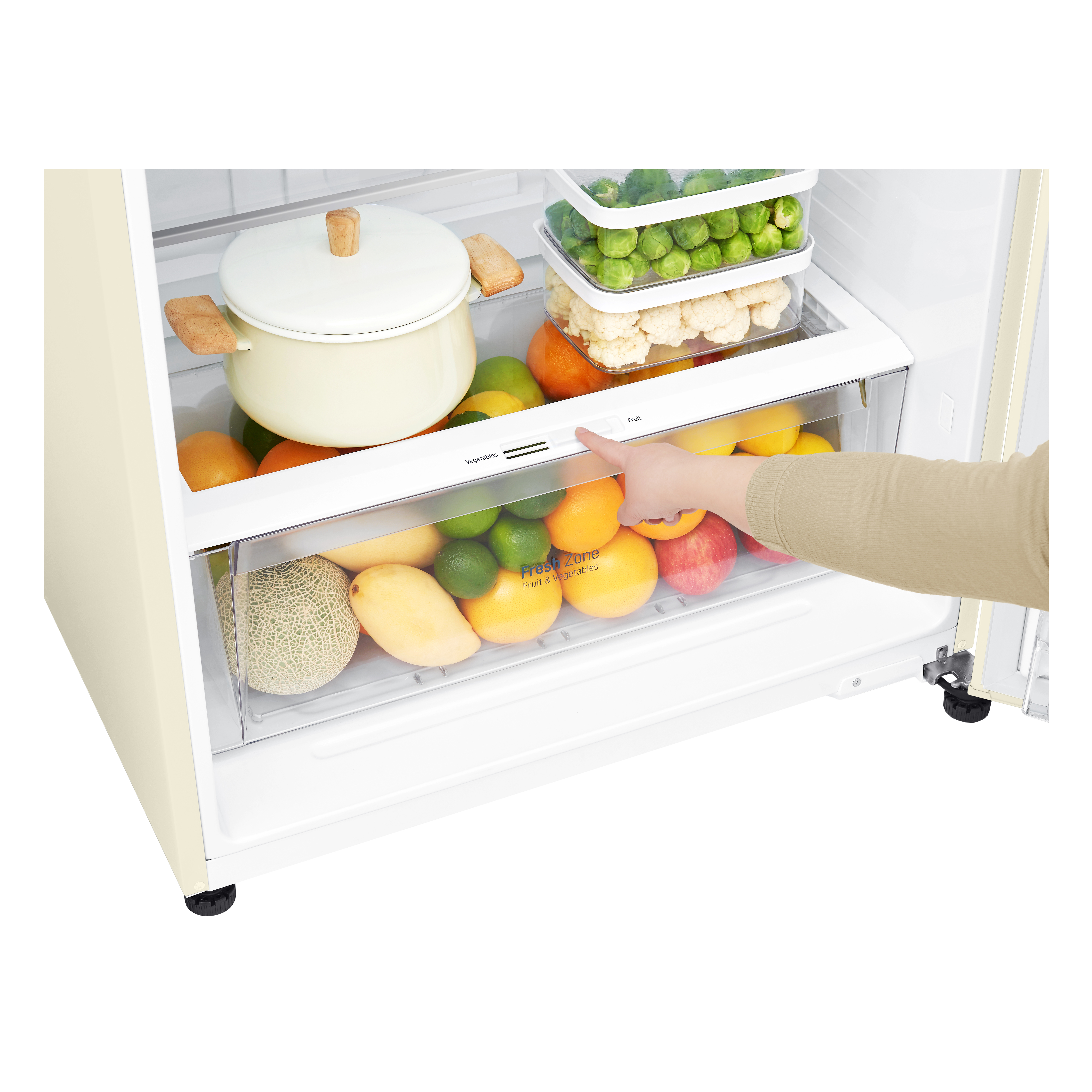 Interno di un frigorifero con frutta e verdura. Una mano regola il cassetto da verdura a frutta.