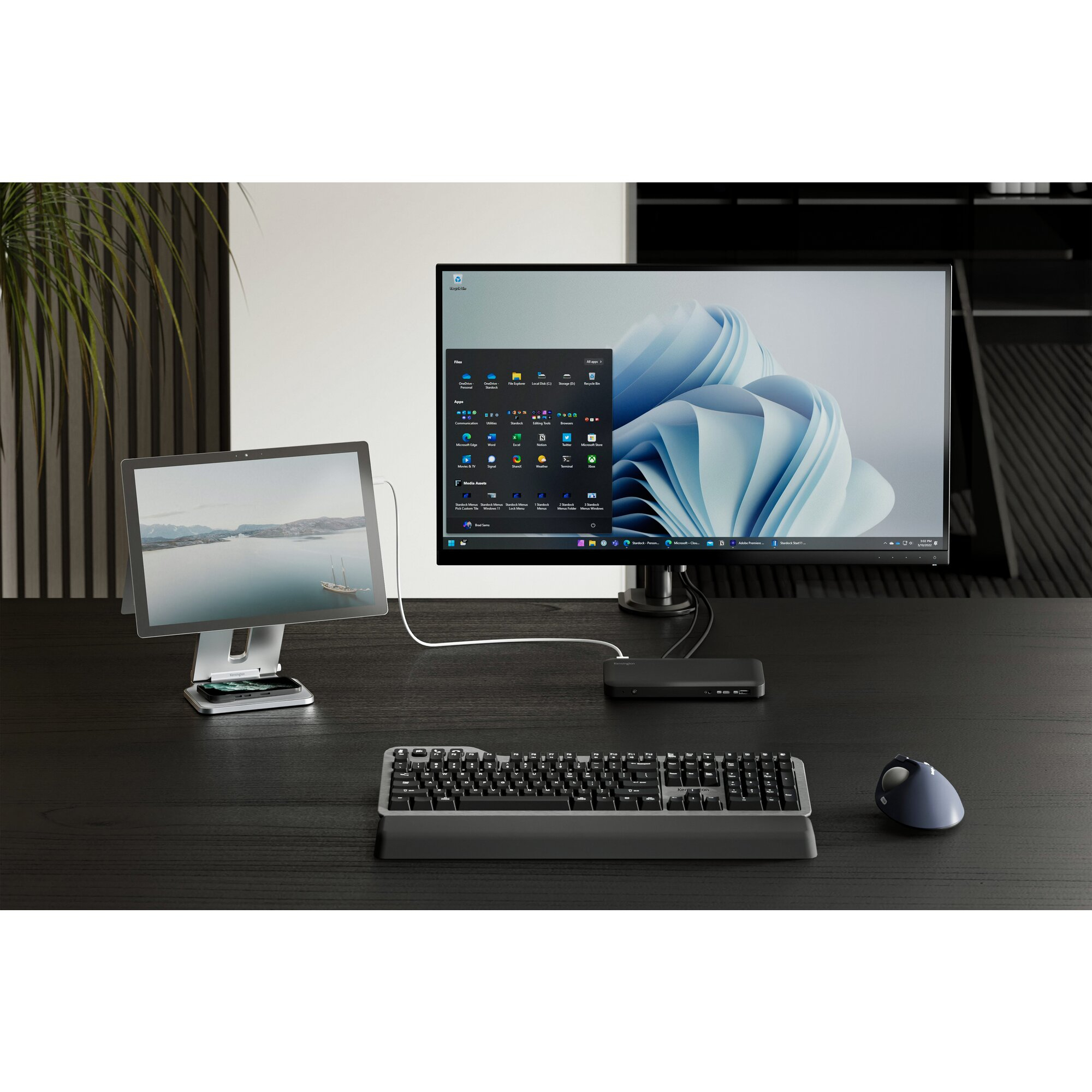 Une configuration de bureau avec un moniteur, une tablette, un clavier et une souris. Le moniteur affiche une interface Windows.