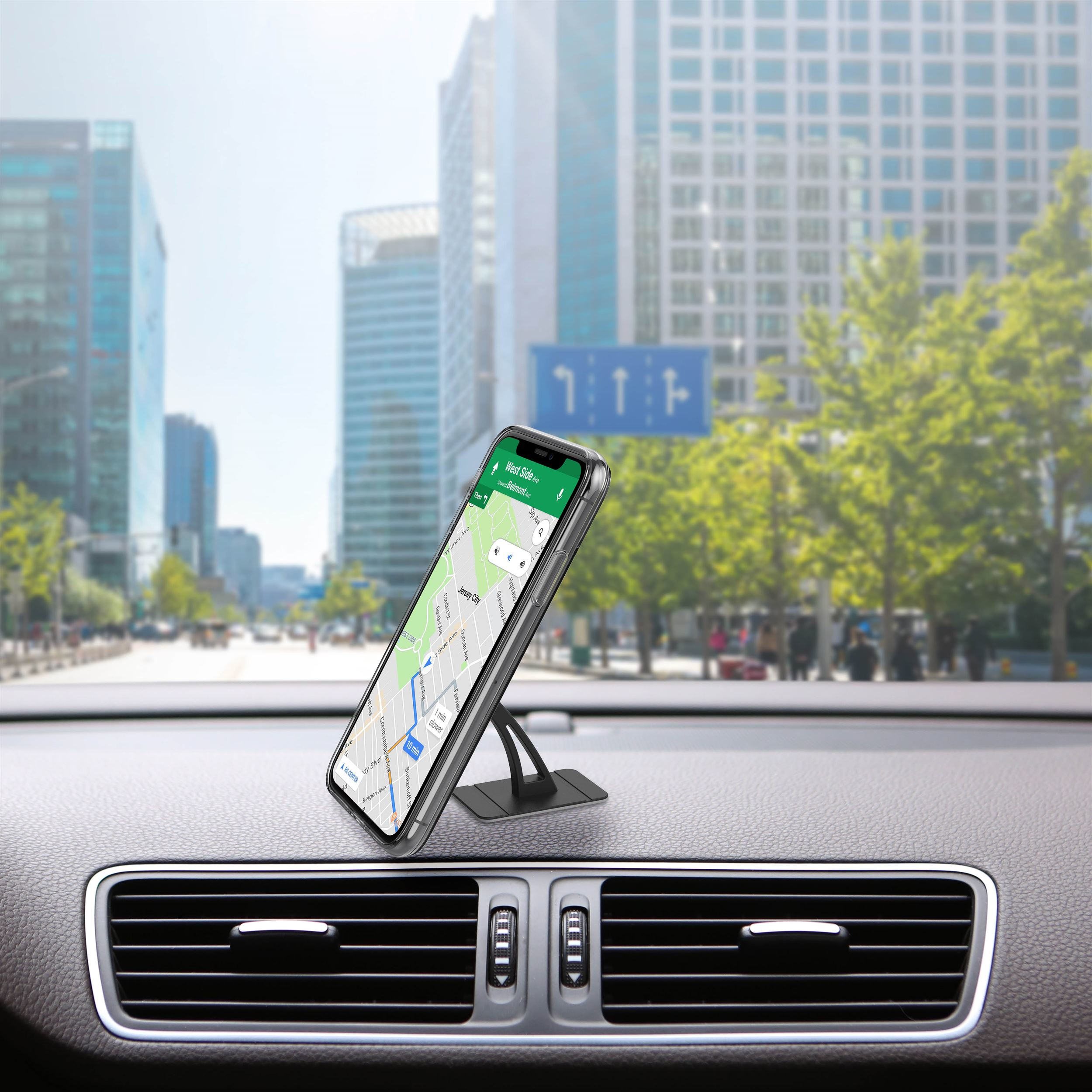Ein Telefon mit Navigation befindet sich auf dem Armaturenbrett eines Autos. Stadtgebäude und Bäume sind im Hintergrund.