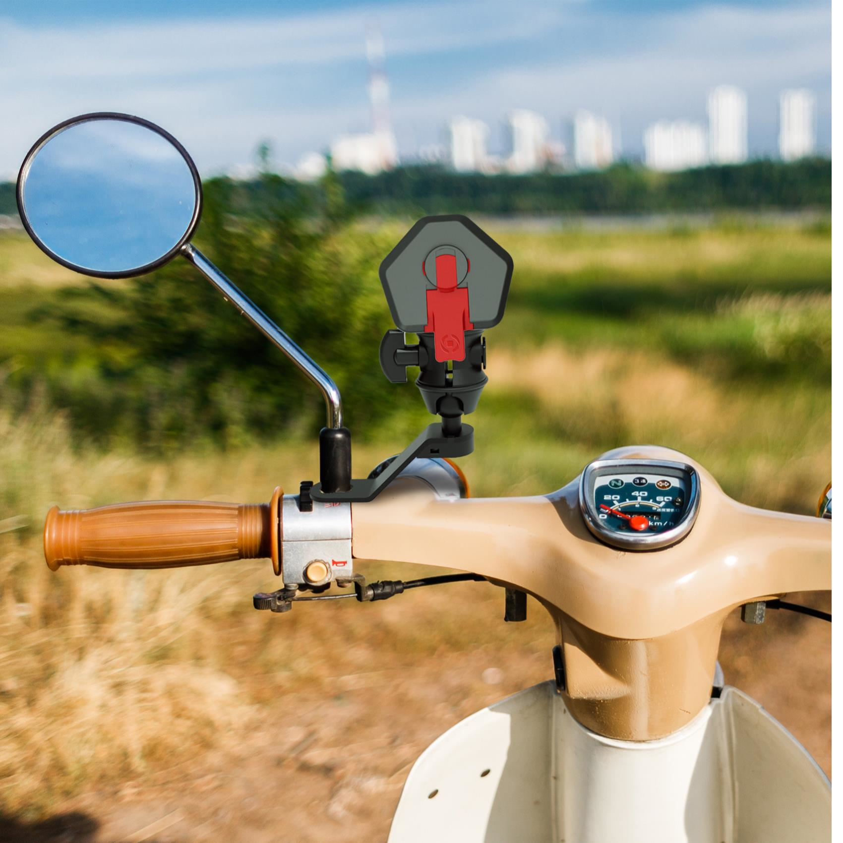 Motorradlenker mit Spiegel und Telefonhalter. Beige- und Brauntöne dominieren. Hintergrund verschwommen mit Grün und Gebäuden.