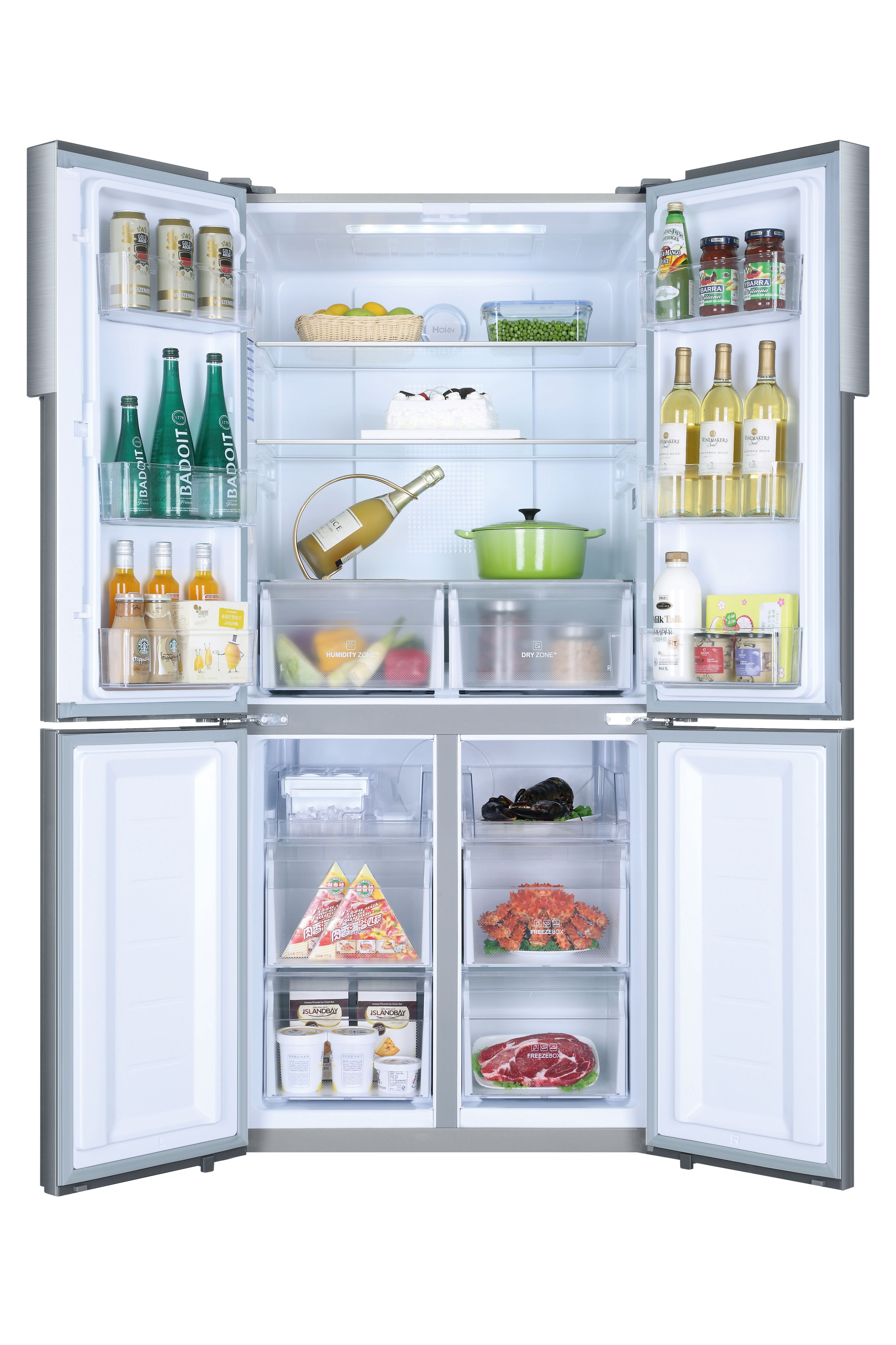 Un refrigerador moderno y abierto lleno de alimentos como bebidas, verduras, pasteles y varios recipientes de alimentos.