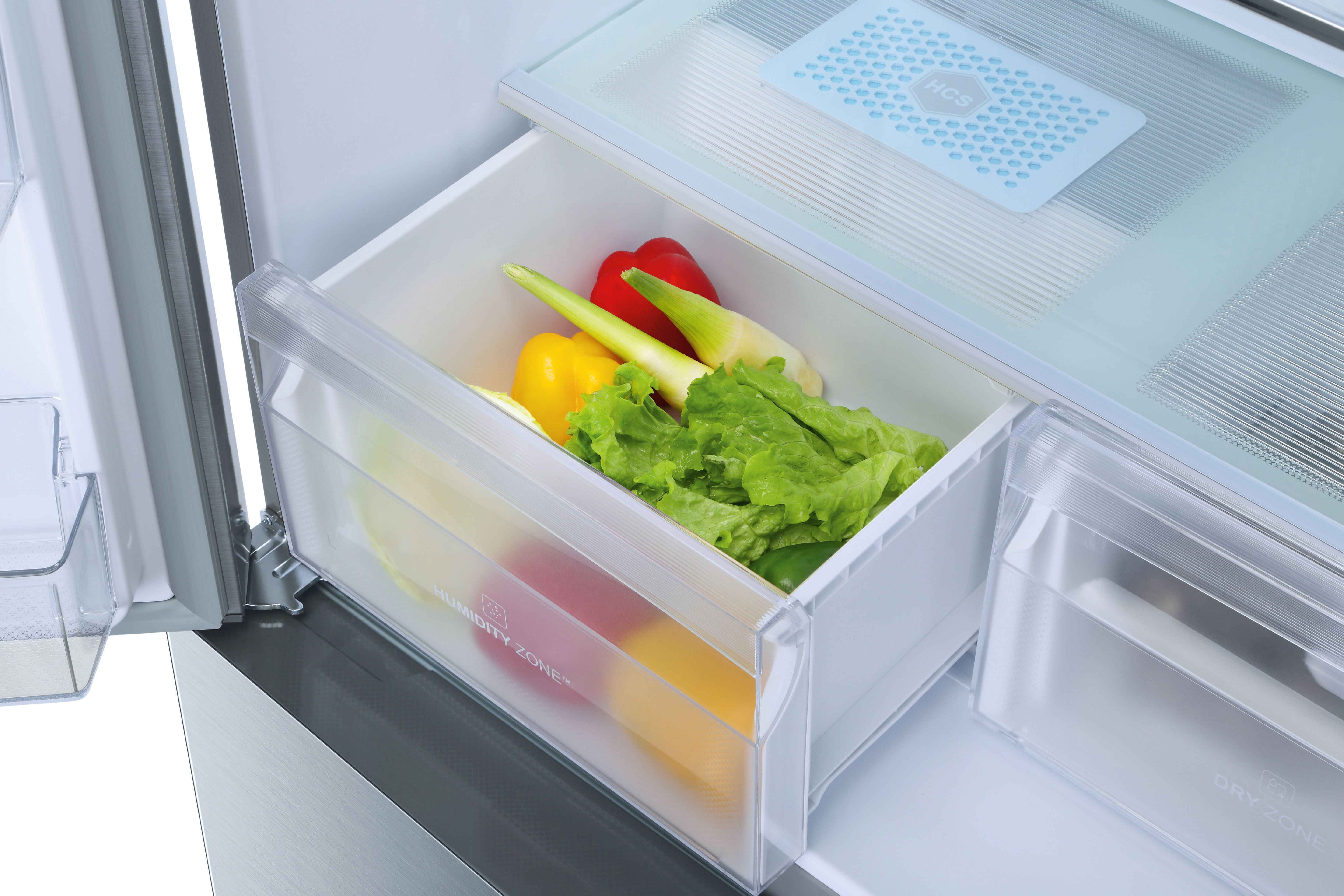 Cajón de nevera con verduras: lechuga, pimientos y cebolletas. Etiqueta Humidity Zone visible.