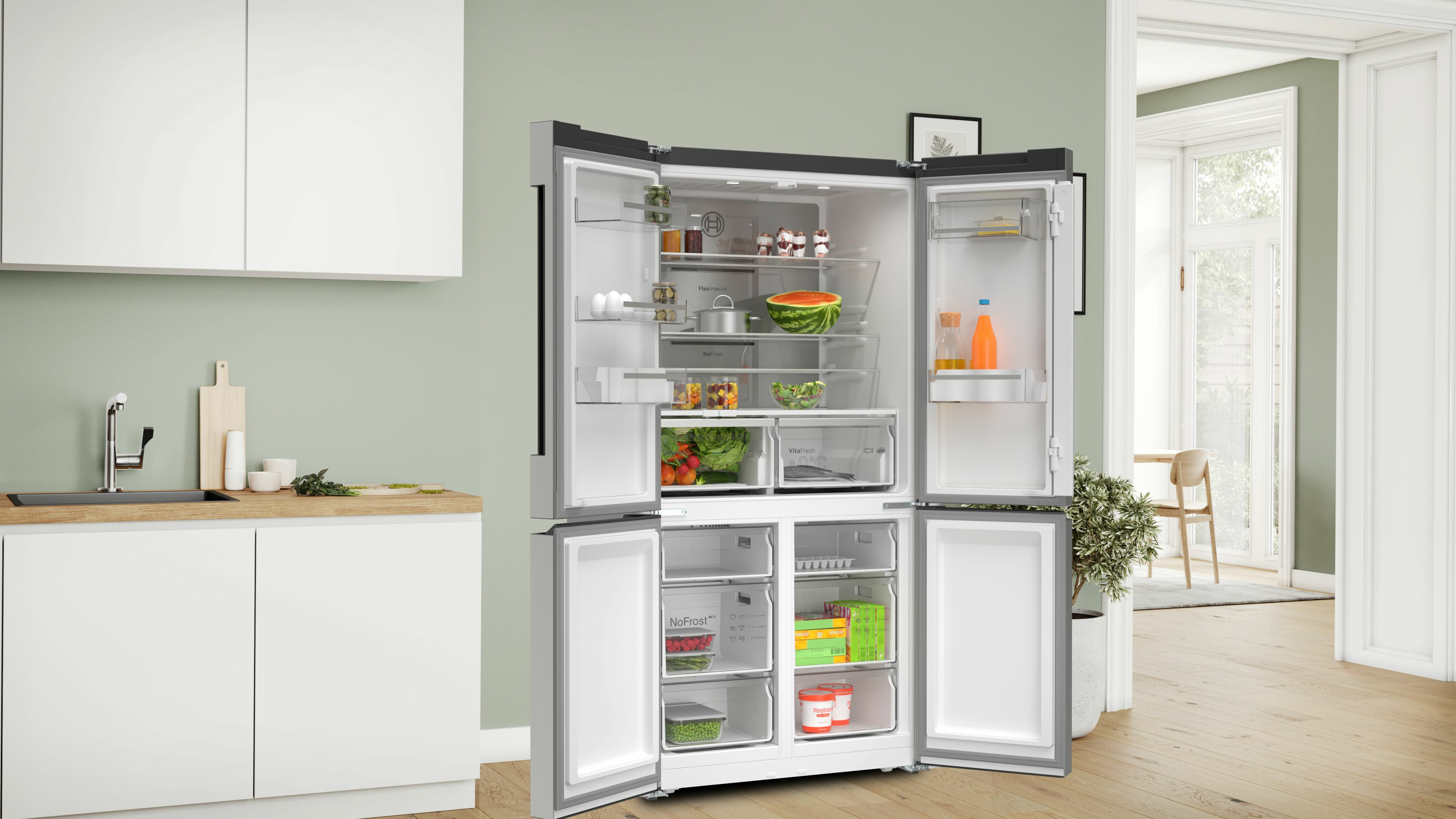 Ein moderner Kühlschrank mit offenen Türen, der Lebensmittel im Inneren zeigt. Küchenzeile mit Spüle und Schneidebrett links.