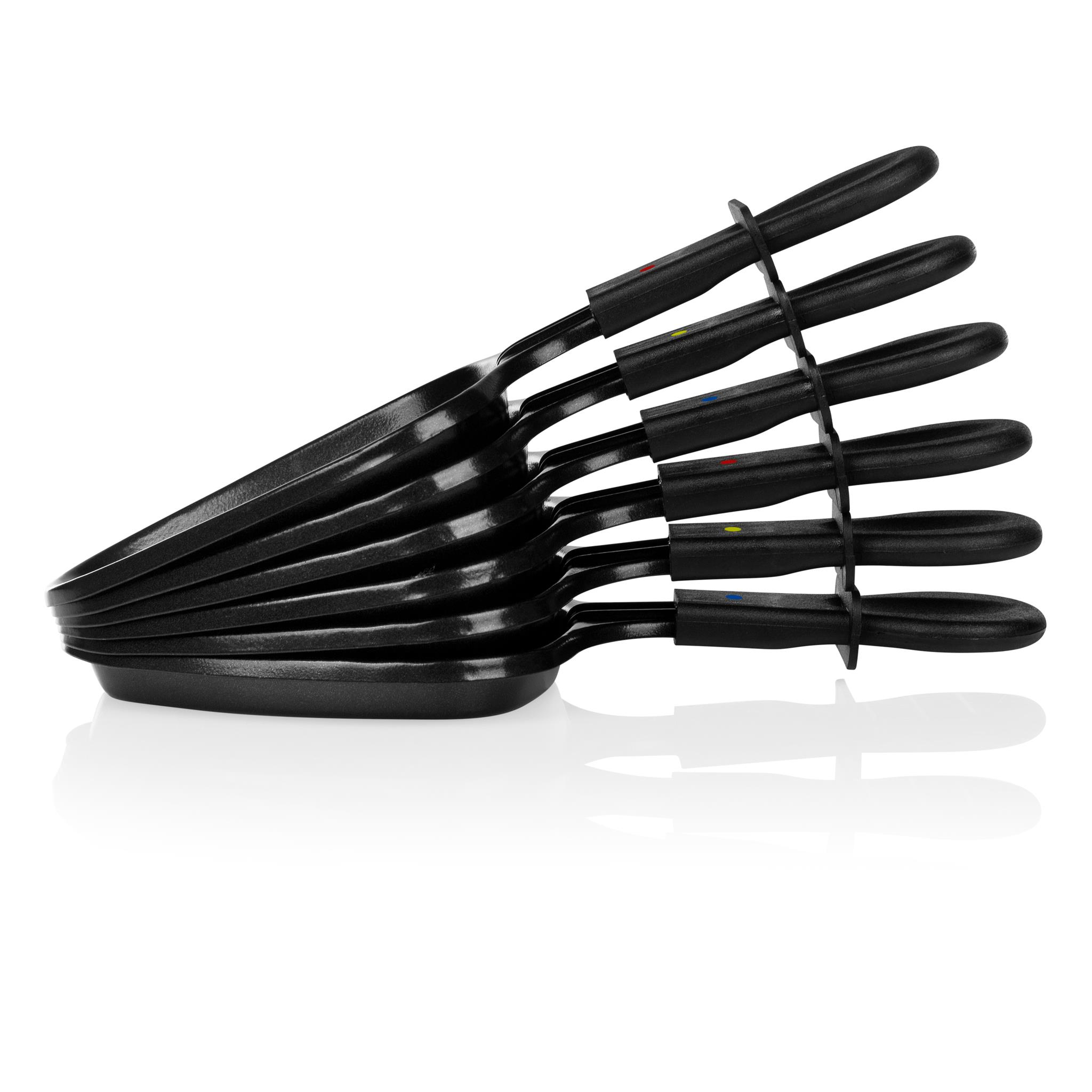 Stos czarnych patelni do raclette, z czarnymi uchwytami i uchwytem. Białe tło z miękkim cieniem.