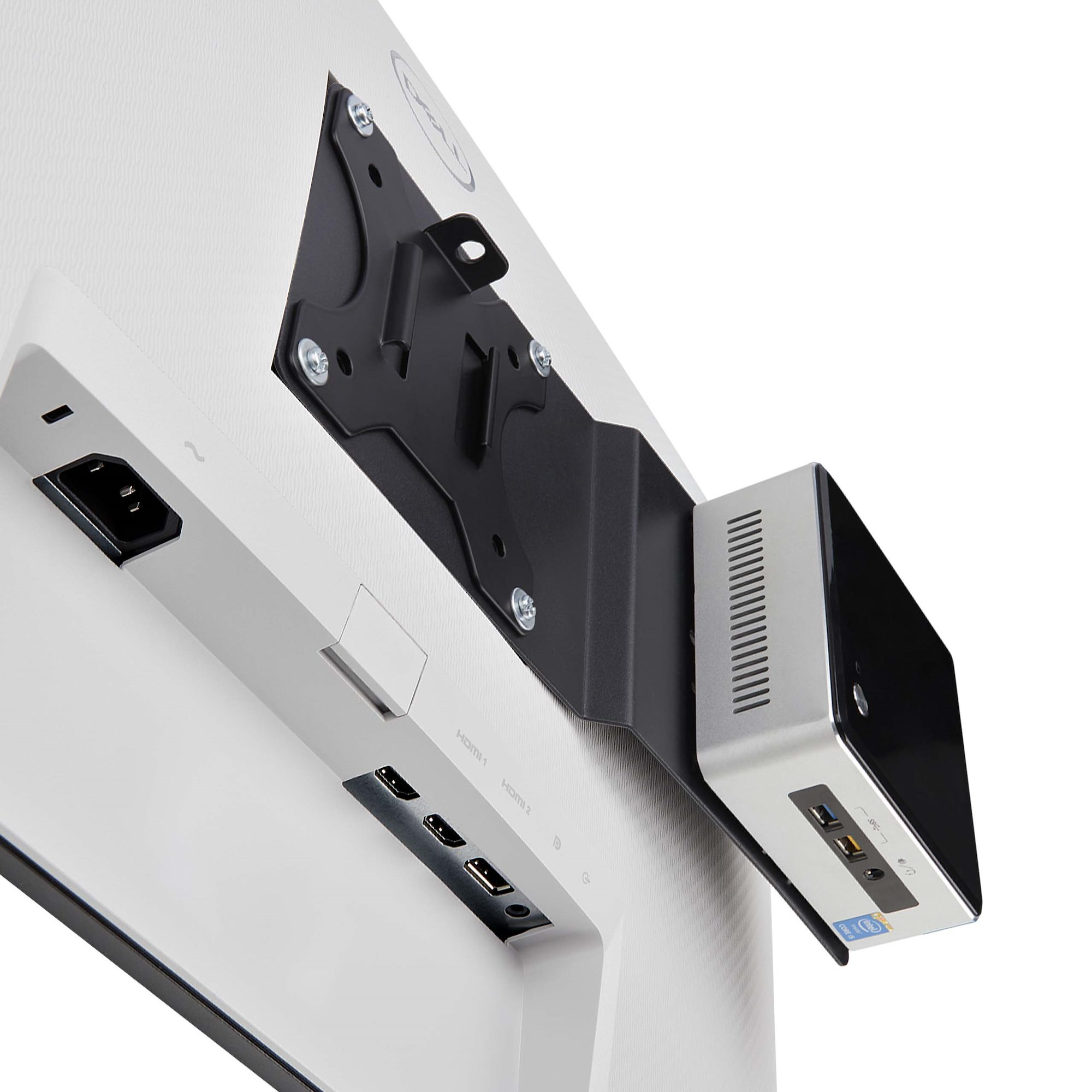 Ein Computer, der an einem weißen Monitor befestigt ist. Der PC ist silber und schwarz. HDMI-Anschlüsse und eine Steckdose sind sichtbar.