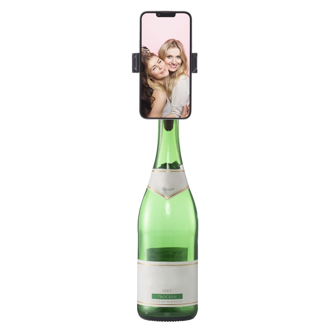 Ein Smartphone mit zwei sich umarmenden Frauen ist auf einer grünen Sektflasche montiert. Die Flasche hat ein weißes Etikett. Weißer Hintergrund.