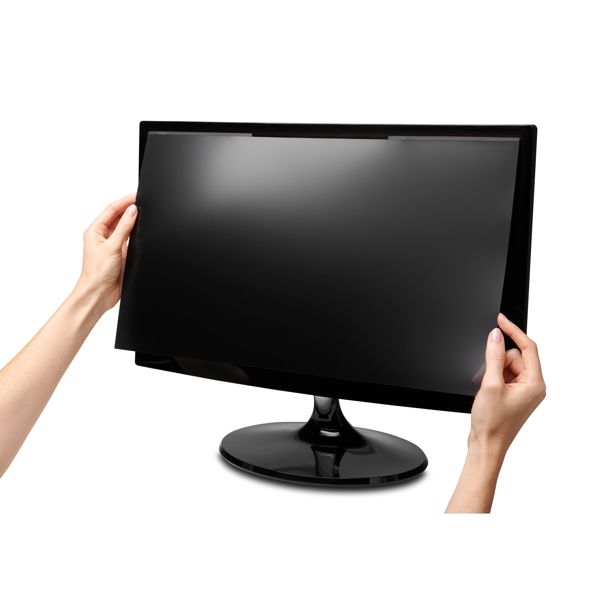 Manos sosteniendo un monitor de computadora negro. La pantalla es negra, el fondo es blanco.