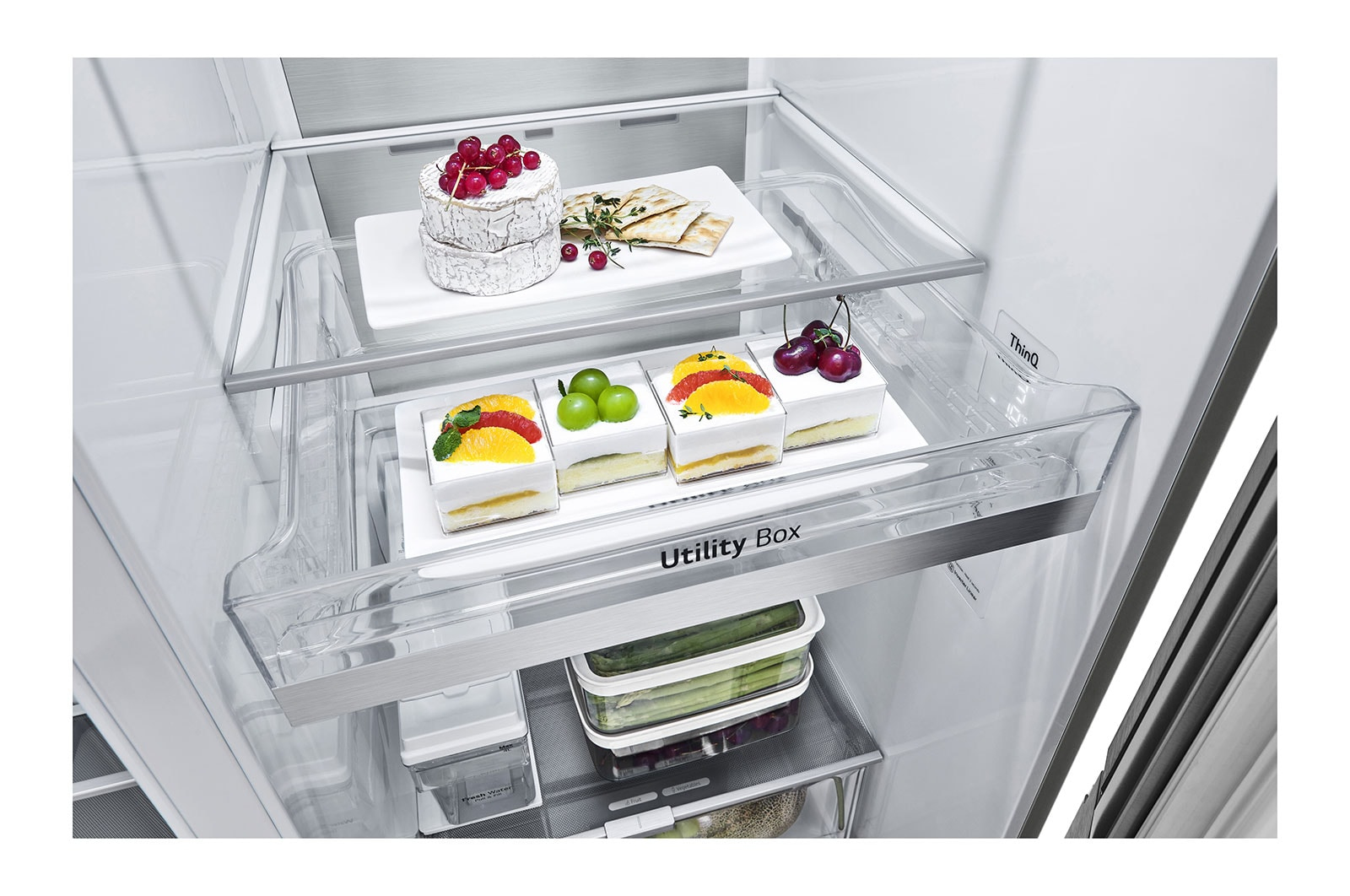 All'interno di un frigorifero: torte con frutta, formaggio, cracker. Ripiani trasparenti, Utility Box e prodotti freschi.