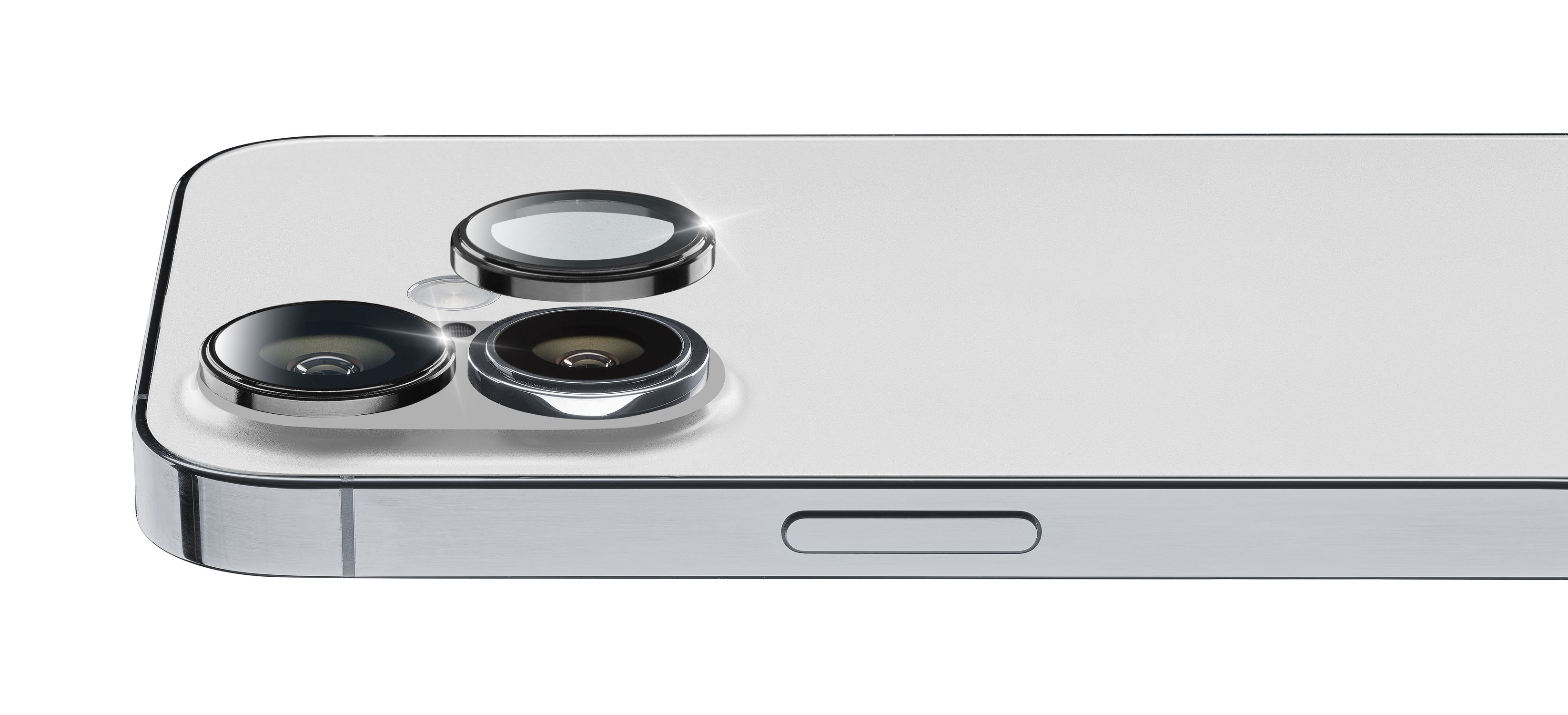 Primo piano del modulo fotocamera di uno smartphone argentato con tre lenti. Il telefono è argentato. Lo sfondo è bianco.