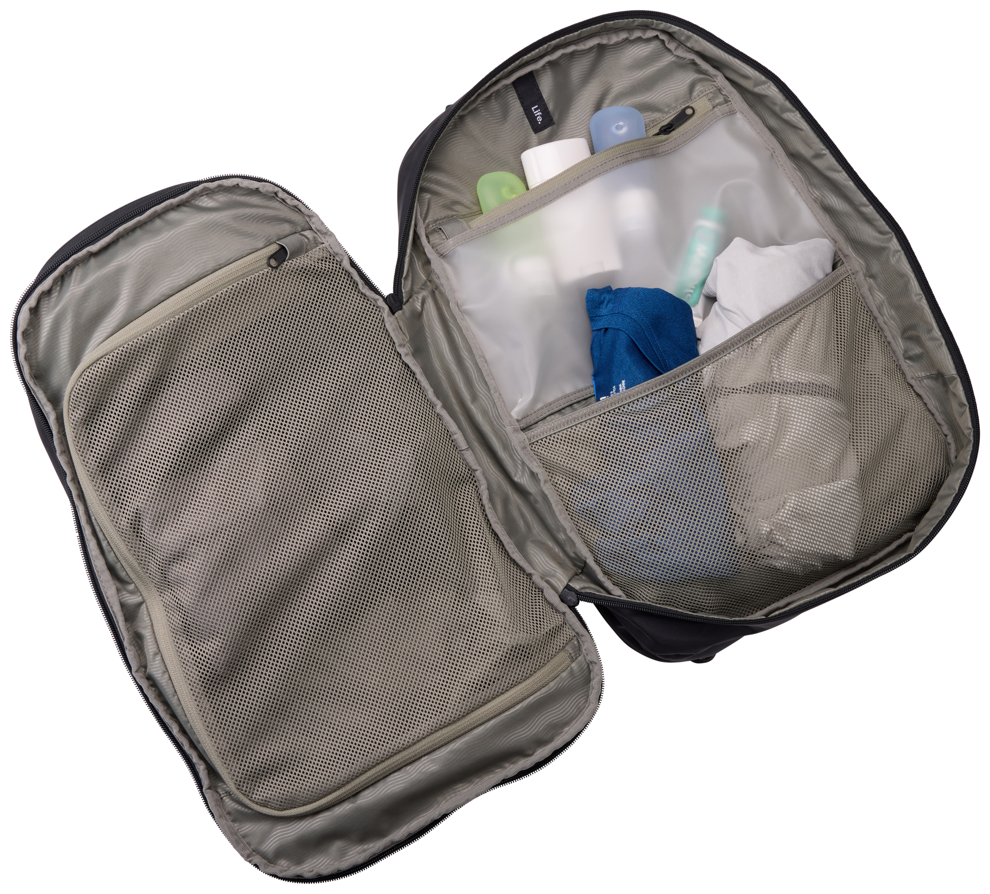 Offene schwarze Reisetasche mit Toilettenartikeln. Enthält Flaschen, ein blaues Tuch und eine Netztasche. Vor weißem Hintergrund.