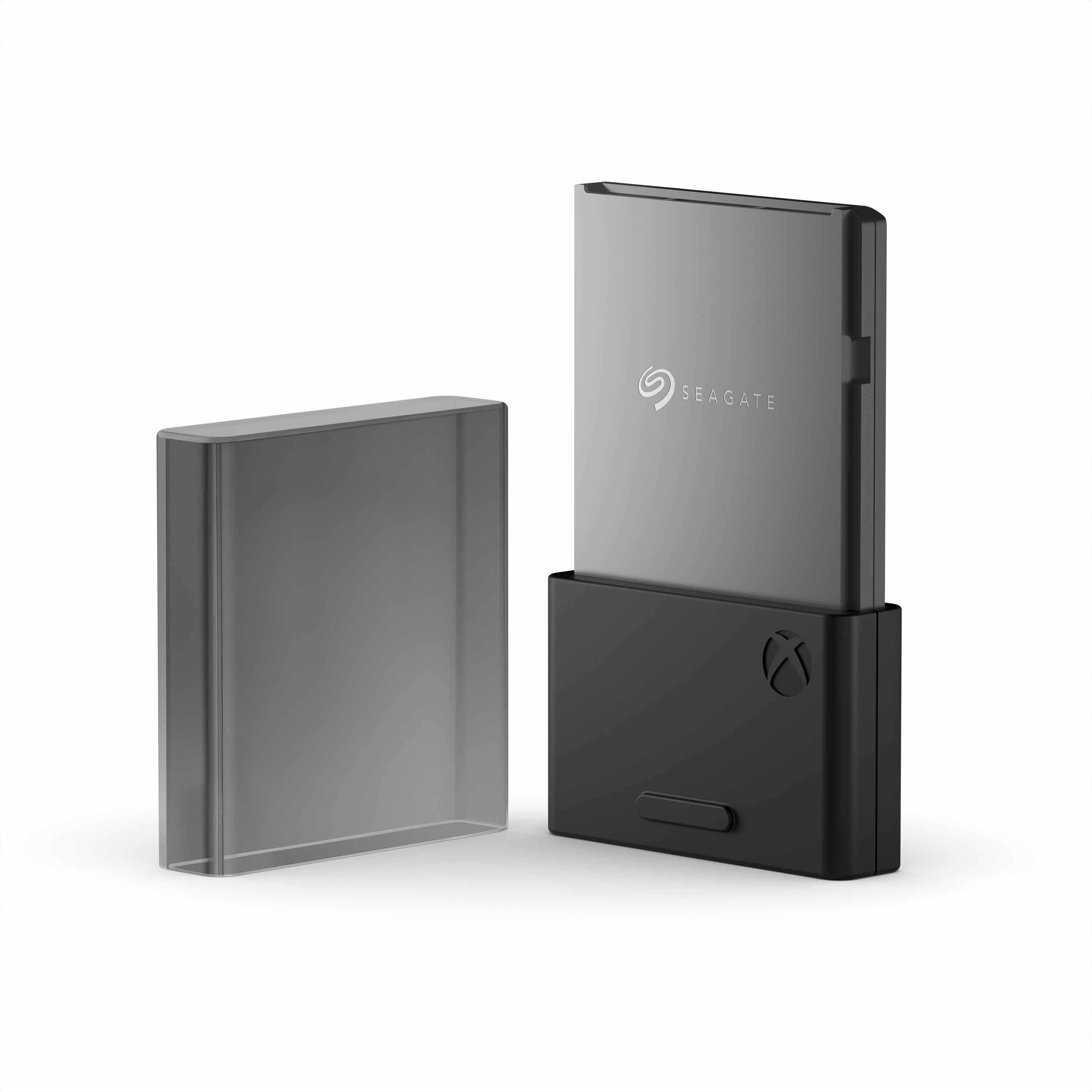 Hard disk esterno Seagate nero con frontale grigio. Accanto, un contenitore trasparente.