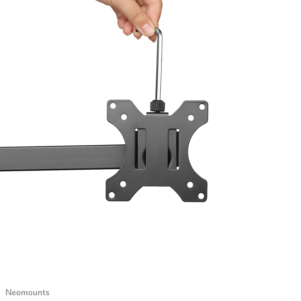 Hand holding a wrench over a black metal bracket with holes. The bracket is connected to a dark metal arm.