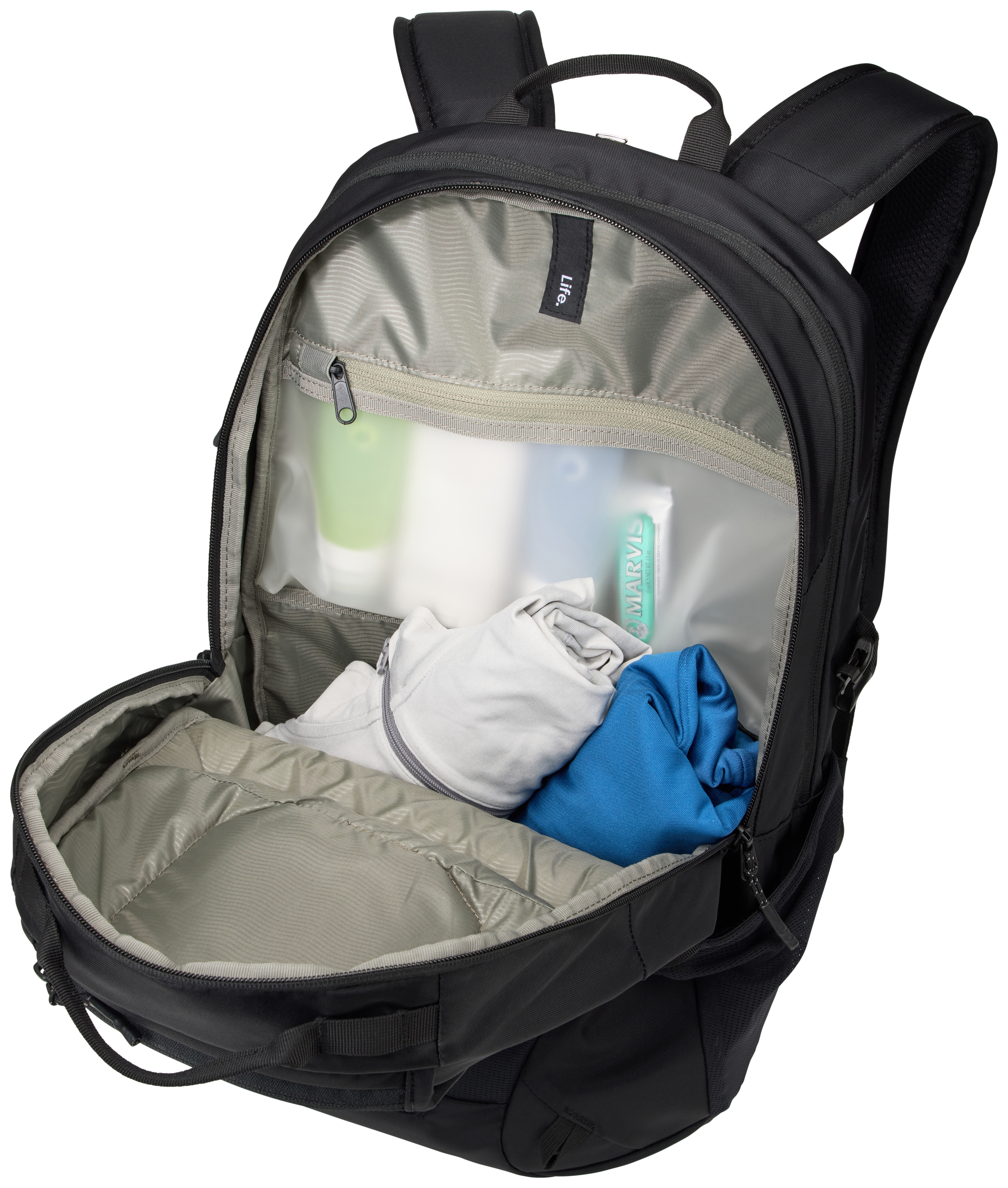 Offener schwarzer Rucksack mit Kleidung und Toilettenartikeln. Enthält weißes Hemd, blaues Hemd und Zahnpasta.