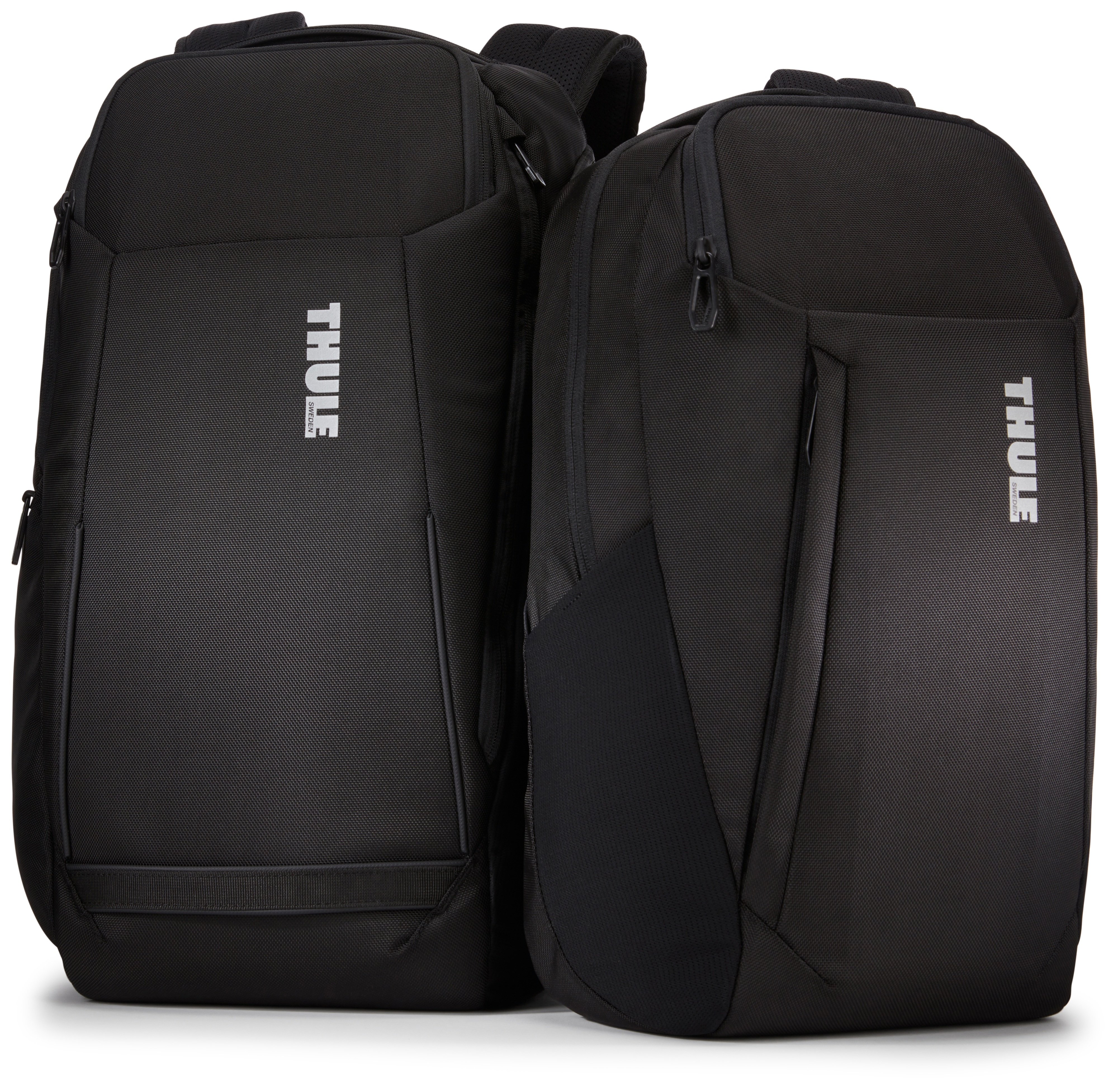 Zwei schwarze Thule-Rucksäcke auf weißem Hintergrund. Einer ist größer mit einer Vordertasche, der andere kleiner.