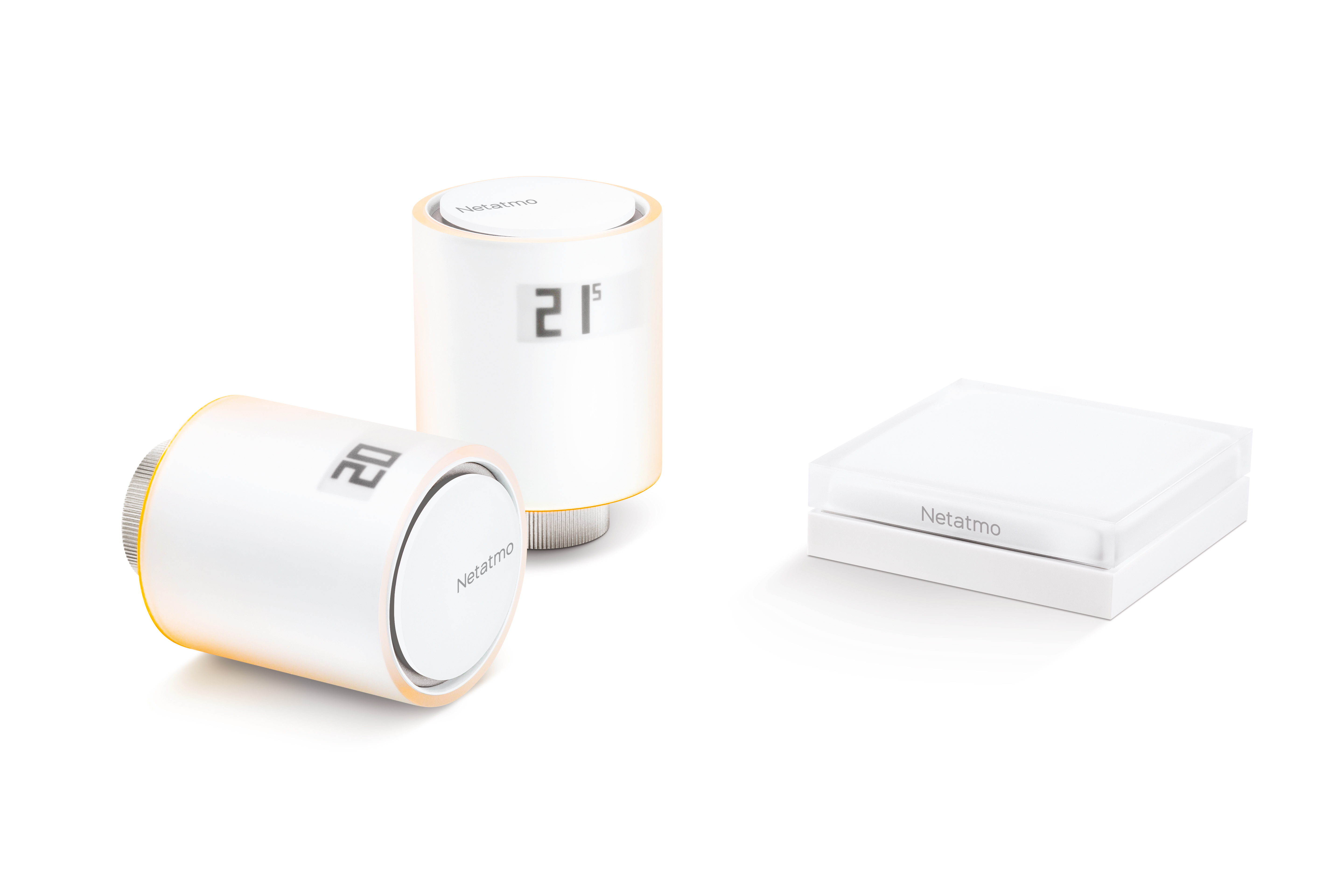 Three white Netatmo devices on a white background. Two are thermostats, displaying temperatures. The third is a square.