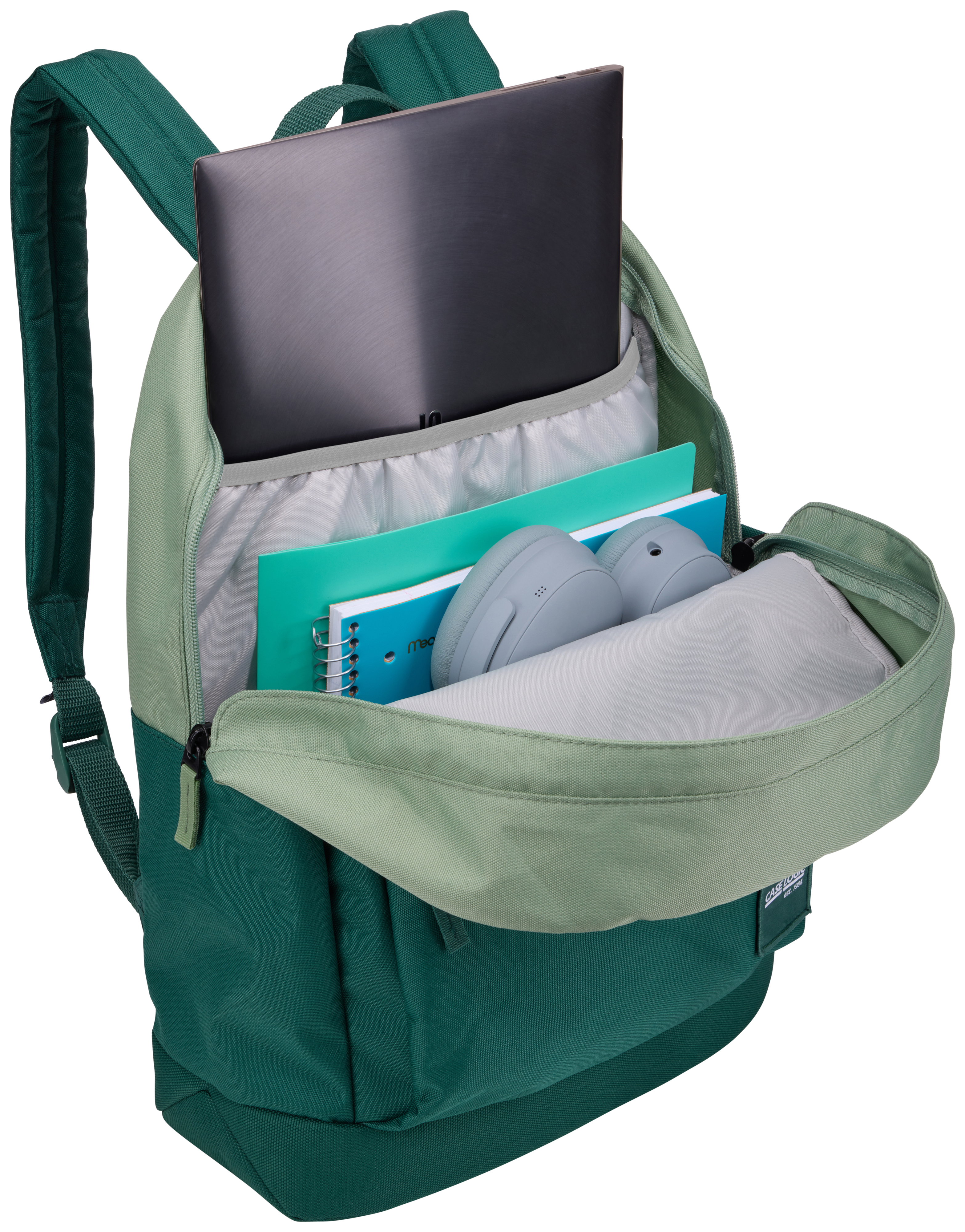 Grüner Rucksack mit Laptop, Notizbüchern und Kopfhörern. Offen, Inhalt sichtbar.