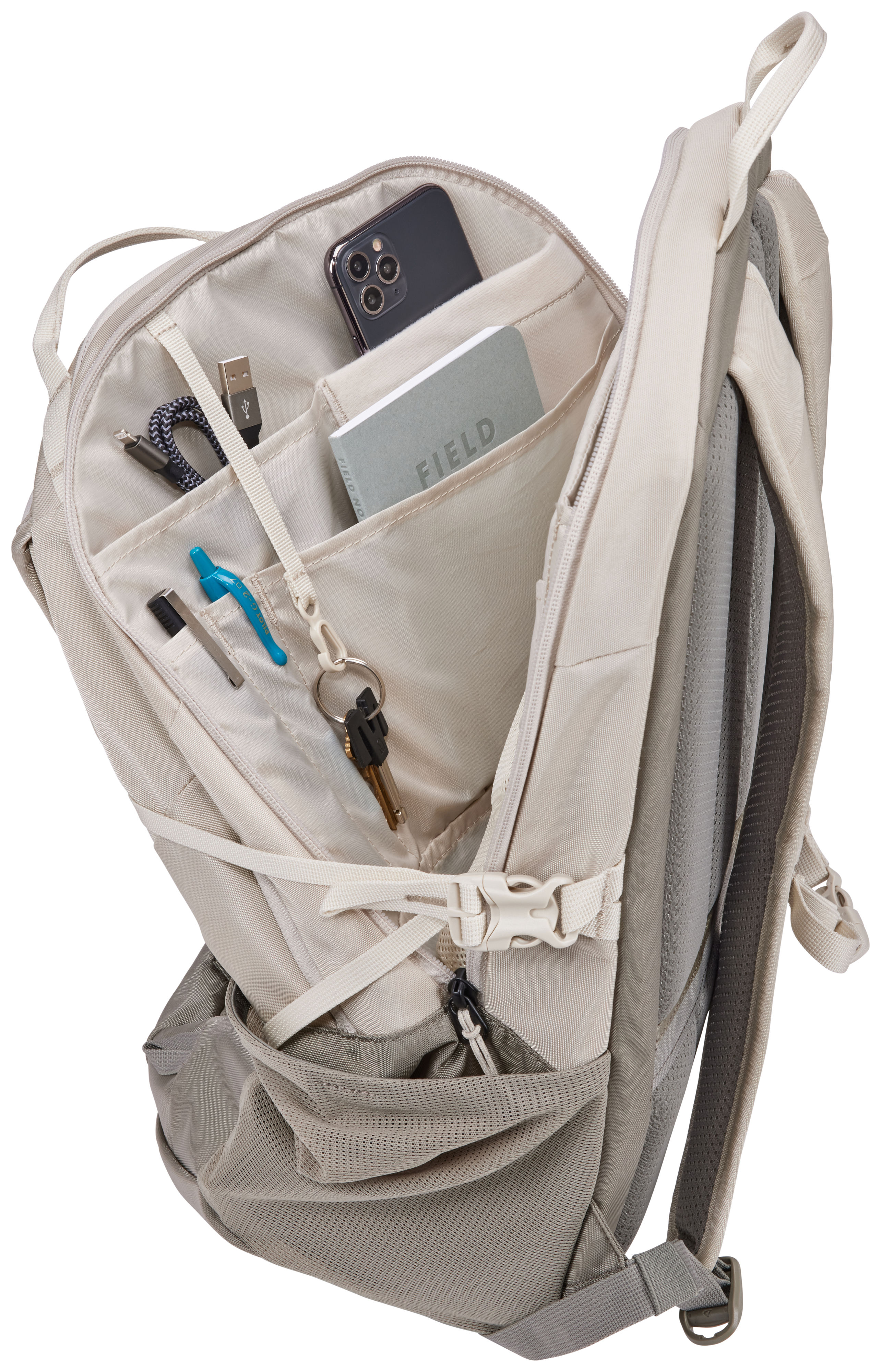 Offener beiger Rucksack mit Telefon, Notizbuch, Stiften, Schlüsseln und Kabeln. Netztasche, Schultergurte und weiße Schnalle.