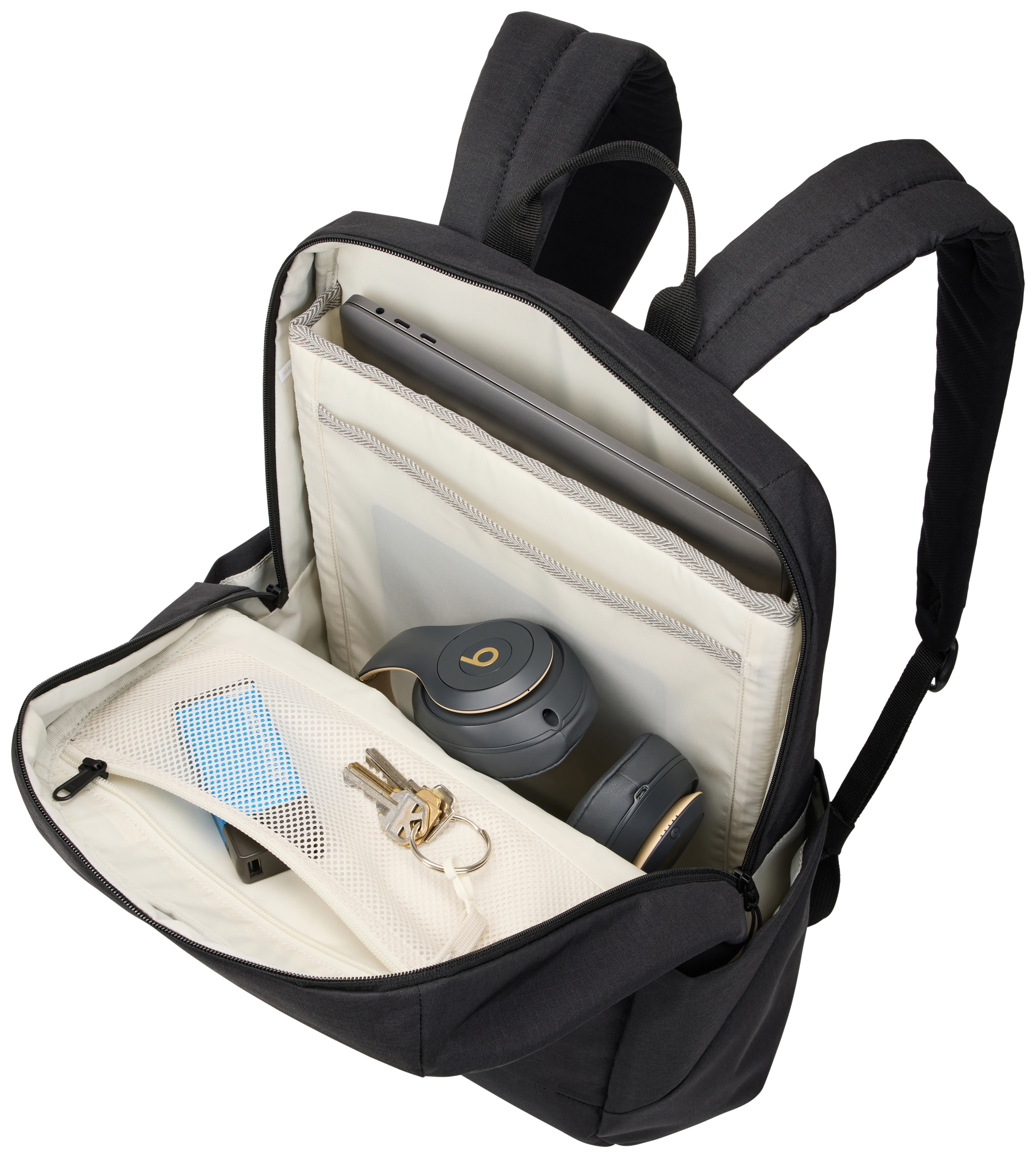 Schwarzer Rucksack offen, mit Laptop, Kopfhörern, Schlüsseln, Telefon und Ladegerät. Cremefarbener Innenraum, schwarze Außenseite.