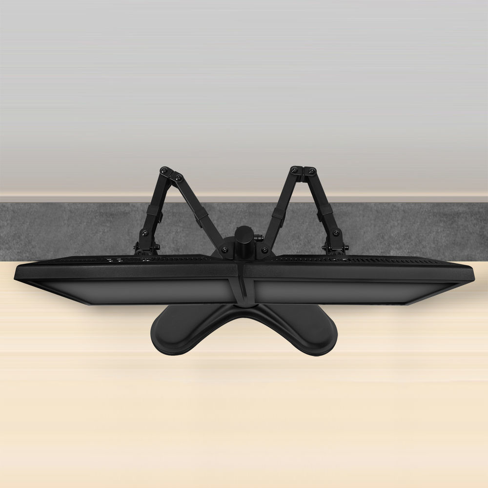 Czarny uchwyt do monitora z dwoma ramionami rozciąga się od podstawy na jasnej drewnianej powierzchni. Szara ściana w tle.