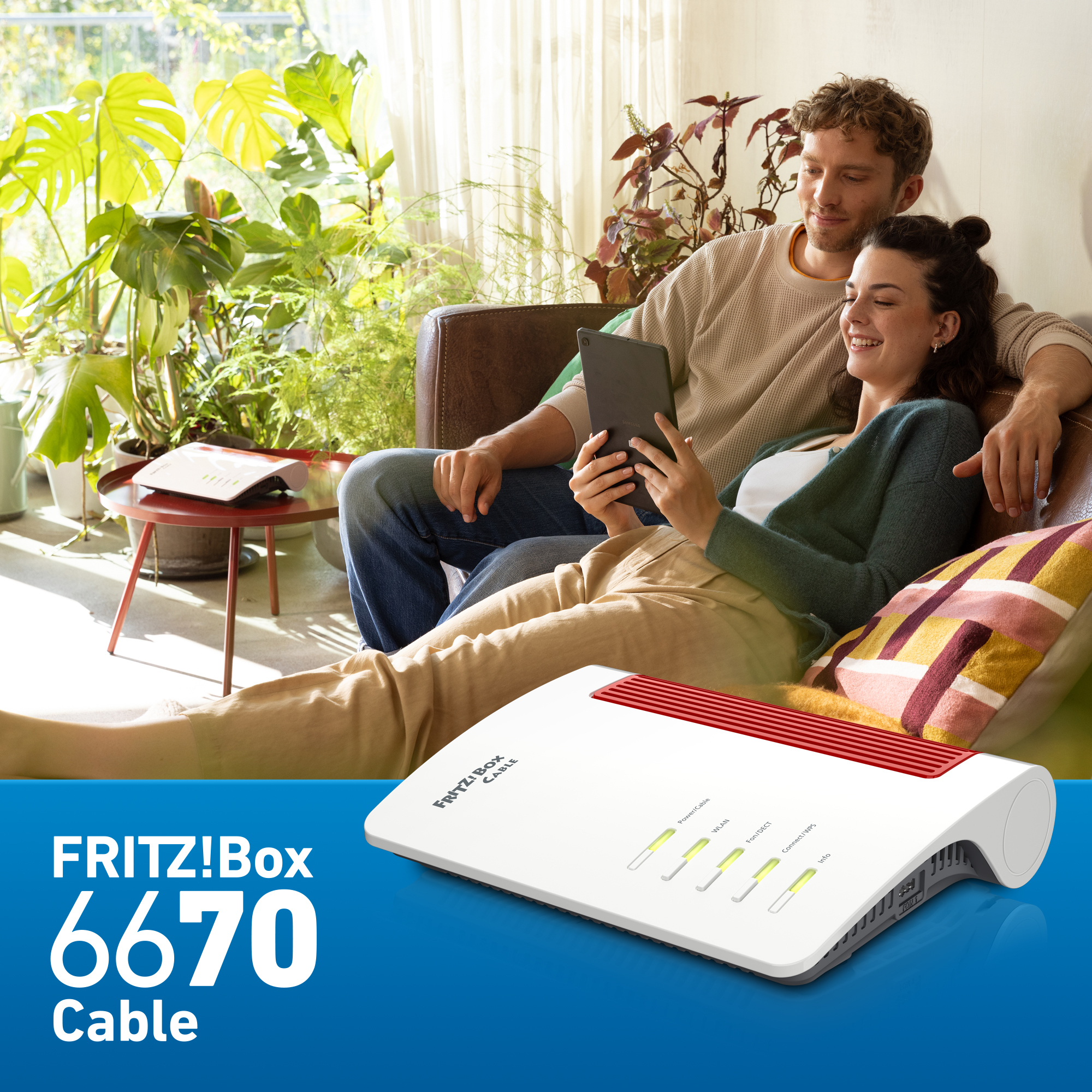 Een stel ontspant op een bank en bekijkt een tablet. Een router staat op de voorgrond. Planten op de achtergrond.