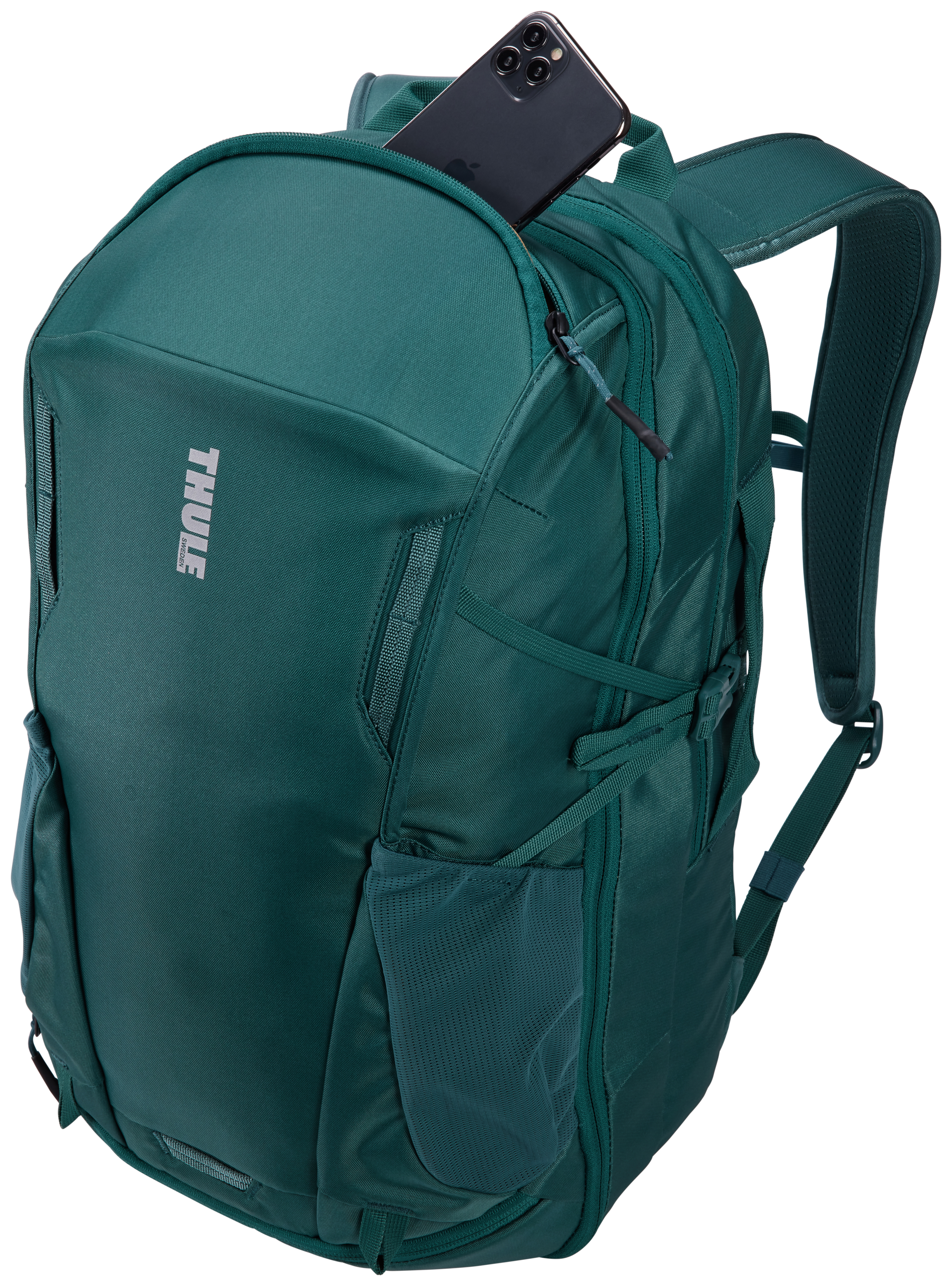 Grüner Rucksack mit einem Telefon, das aus einer Tasche ragt. Thule-Logo sichtbar.