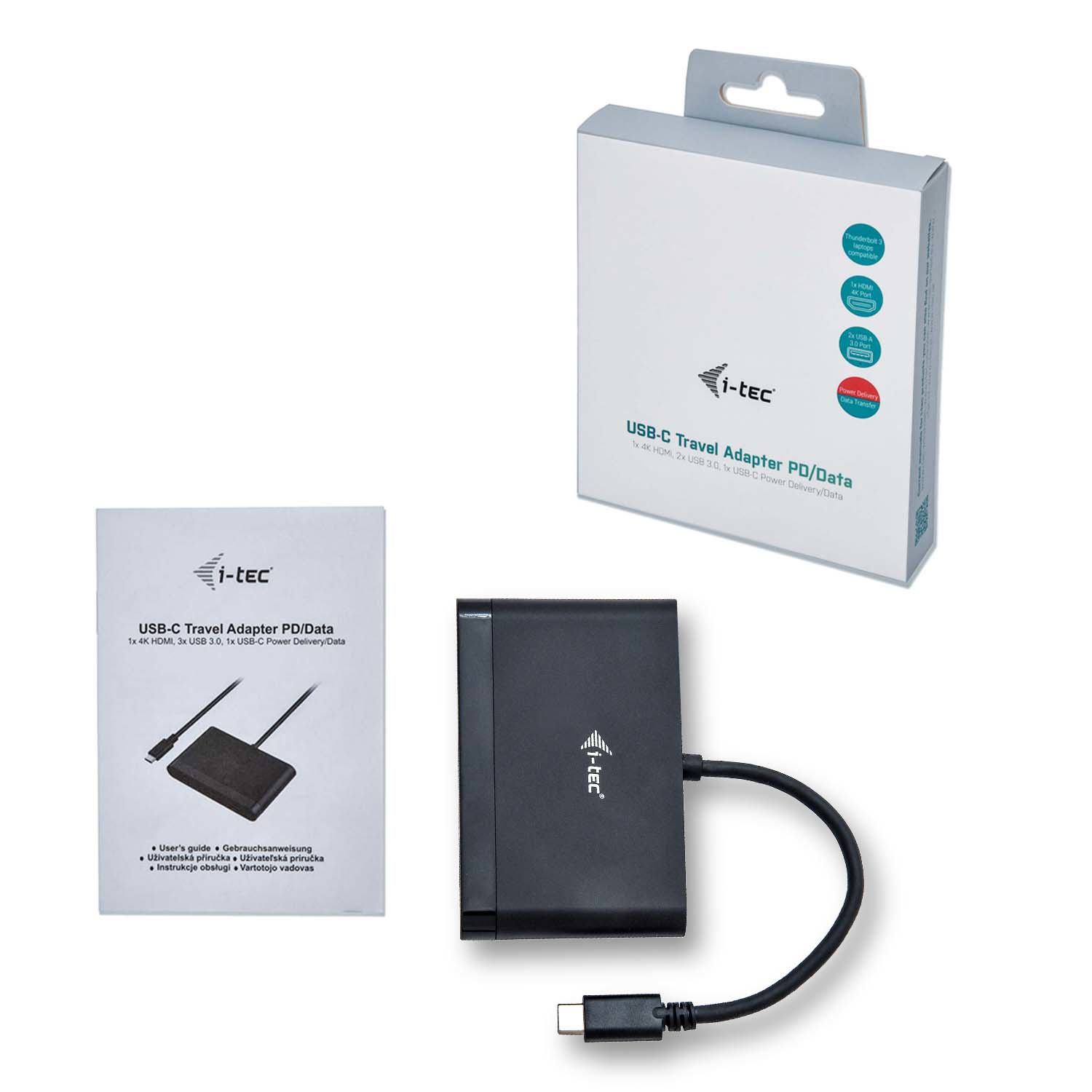 Un adattatore da viaggio USB-C, scatola e manuale su una superficie bianca. L'adattatore è nero, la scatola bianca con testo blu.