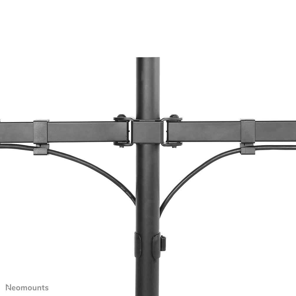 A close-up of a black monitor mount. A vertical pole connects to horizontal arms. Cables are held by clips.