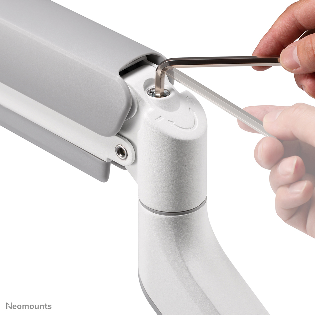 Eine Hand benutzt einen Inbusschlüssel, um eine Schraube an einem weiß-grauen mechanischen Arm festzuziehen. Der Hintergrund ist unscharf.