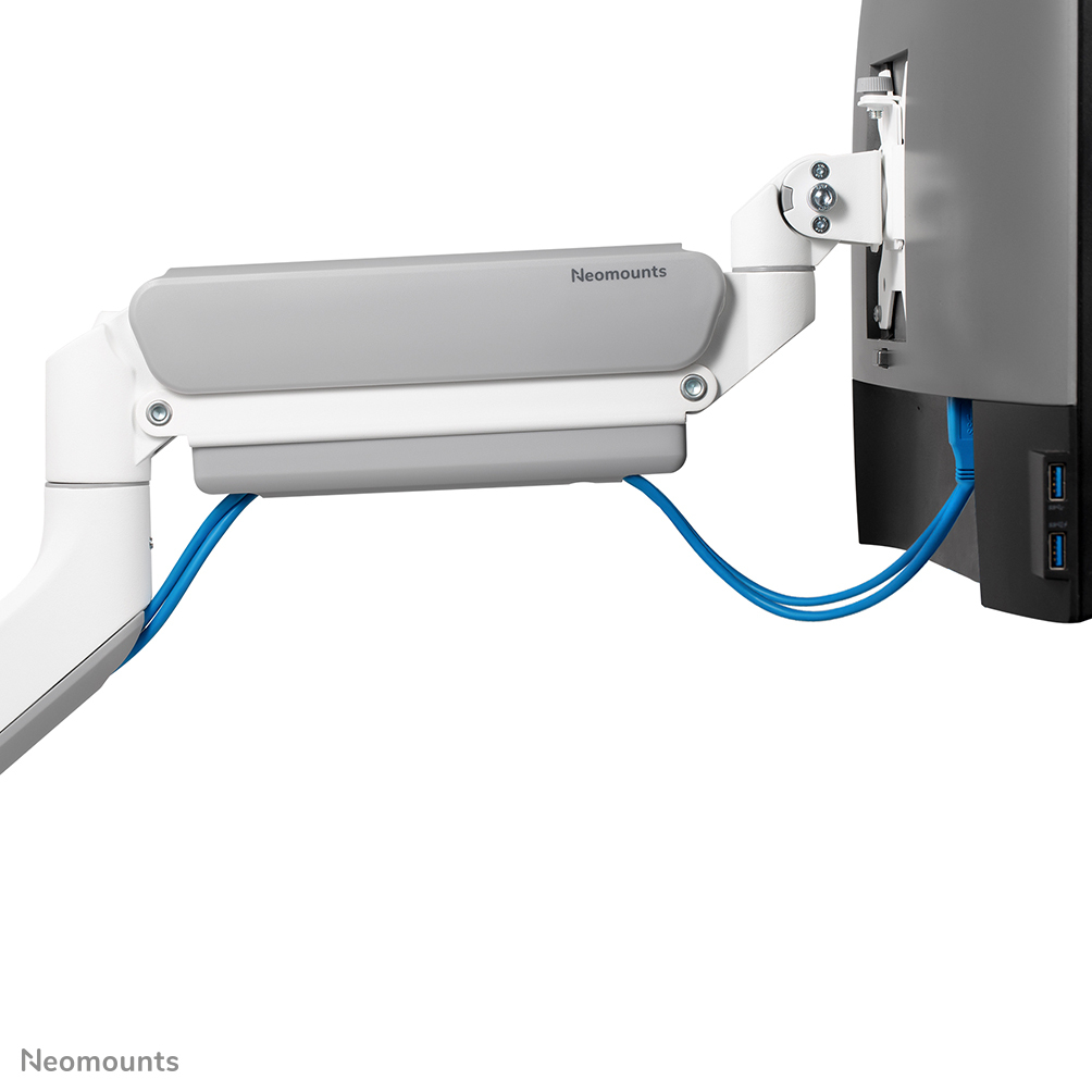 Ein weiß-grauer Monitorarm trägt einen schwarzen Monitor. Blaue Kabel verbinden sich mit dem Monitor. Der Markenname 'Neomounts' ist sichtbar.