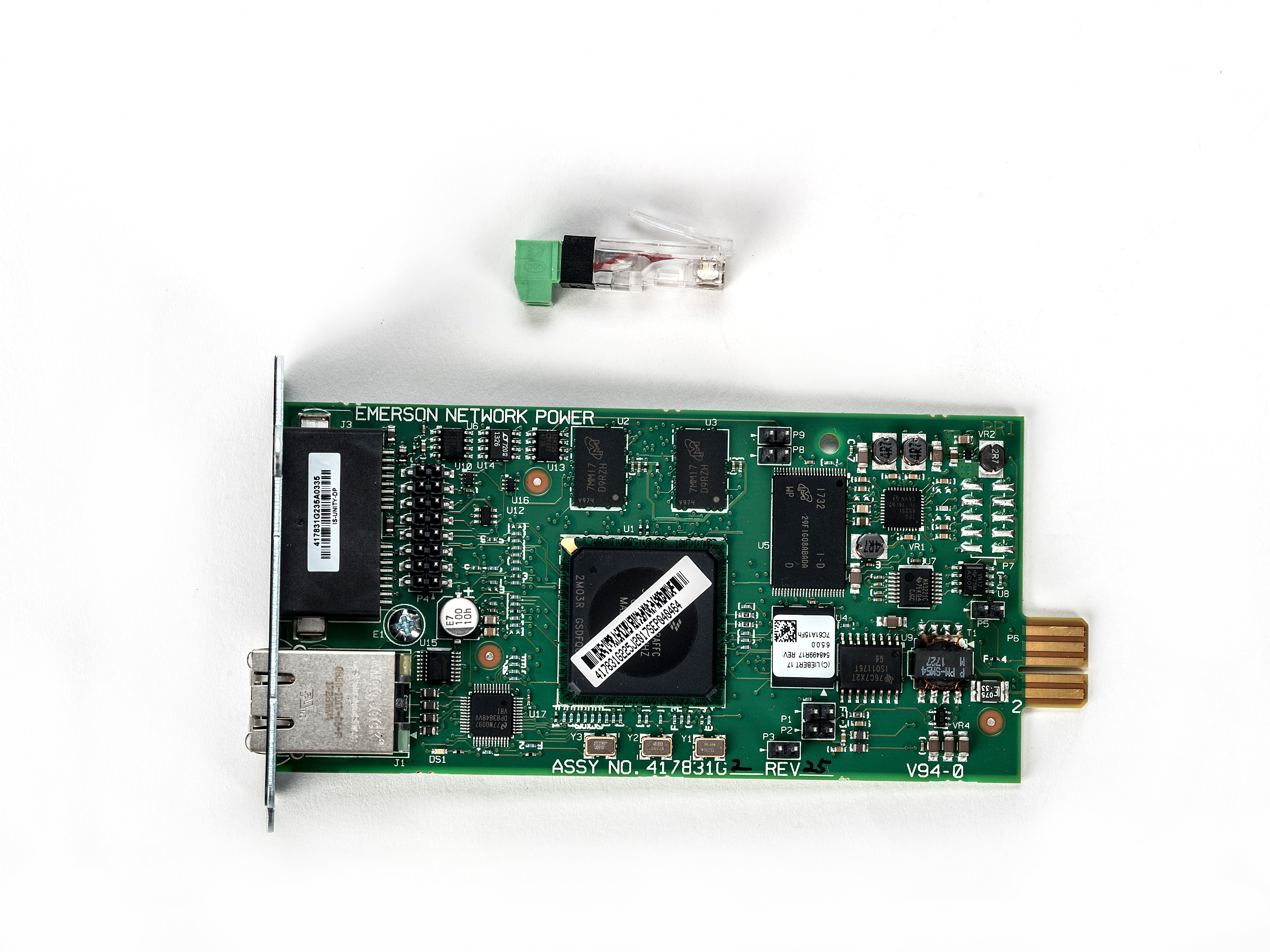 Un circuit imprimé vert avec des puces et des connecteurs, un connecteur vert et noir et un fond blanc.